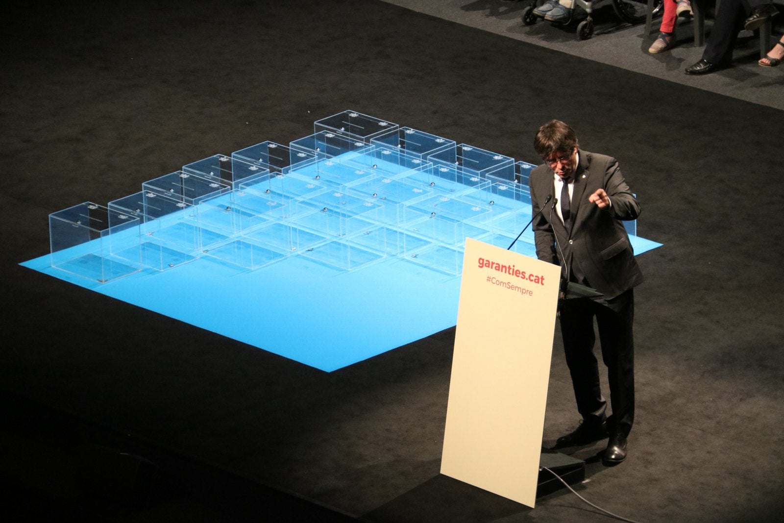 El president de la Generalitat, Carles Puigdemont, parlant des del faristol amb un seguit d'urnes al seu costat