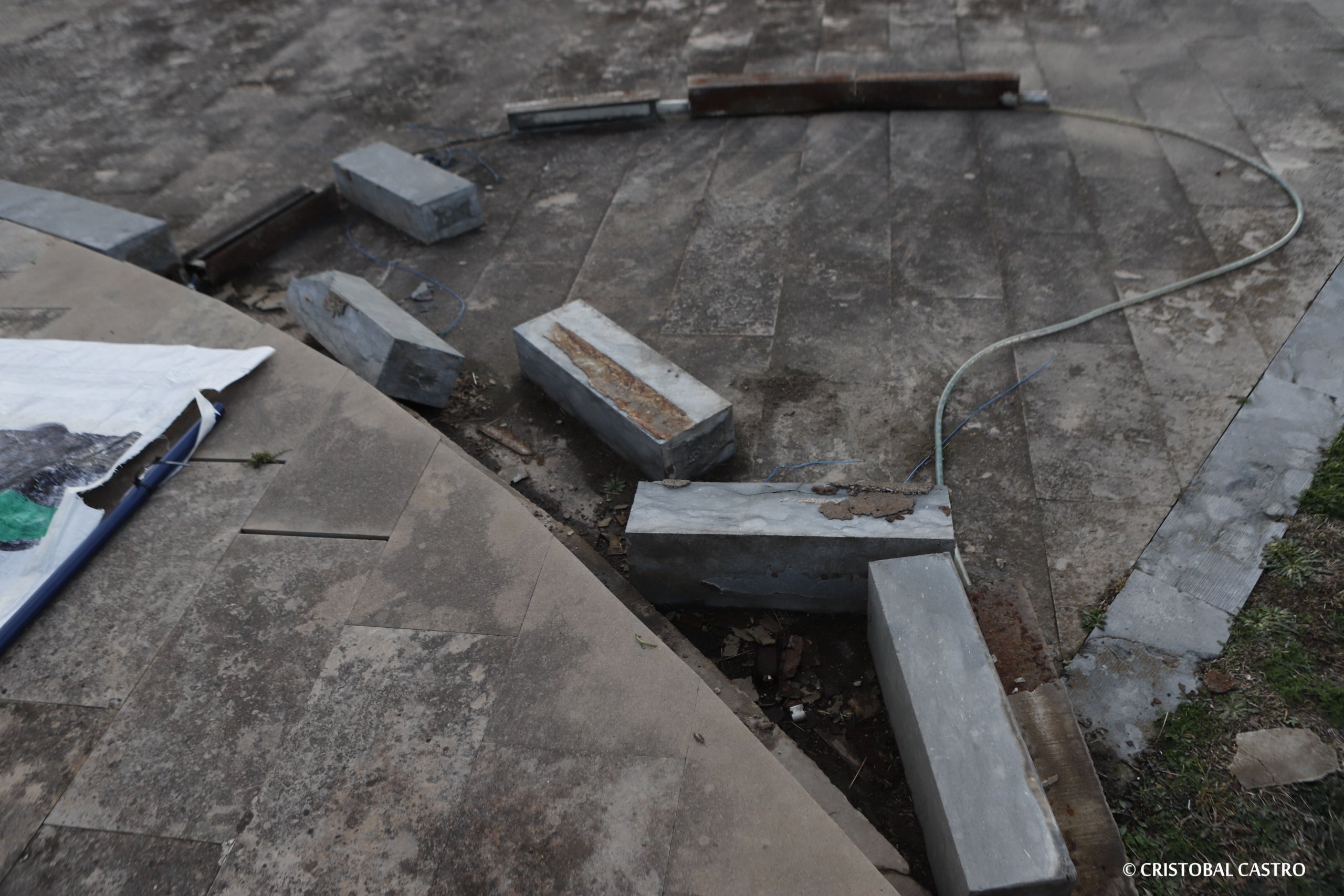 Estat en què es troba la plaça de la Dona Treballadora de Terrassa. L'incivisme i la falta de manteniment han deixat en un estat deplorable la rotonda i el monument. Les rajoles han anat desapareixent, els blocs de ciment han caigut, i els cables s'han despenjat. Ja no només és una qüestió estètica, sinó que representa un perill per a la seguretat dels vianants, i requereix una intervenció urgent, almenys de neteja i sanejament | Cristóbal Castro