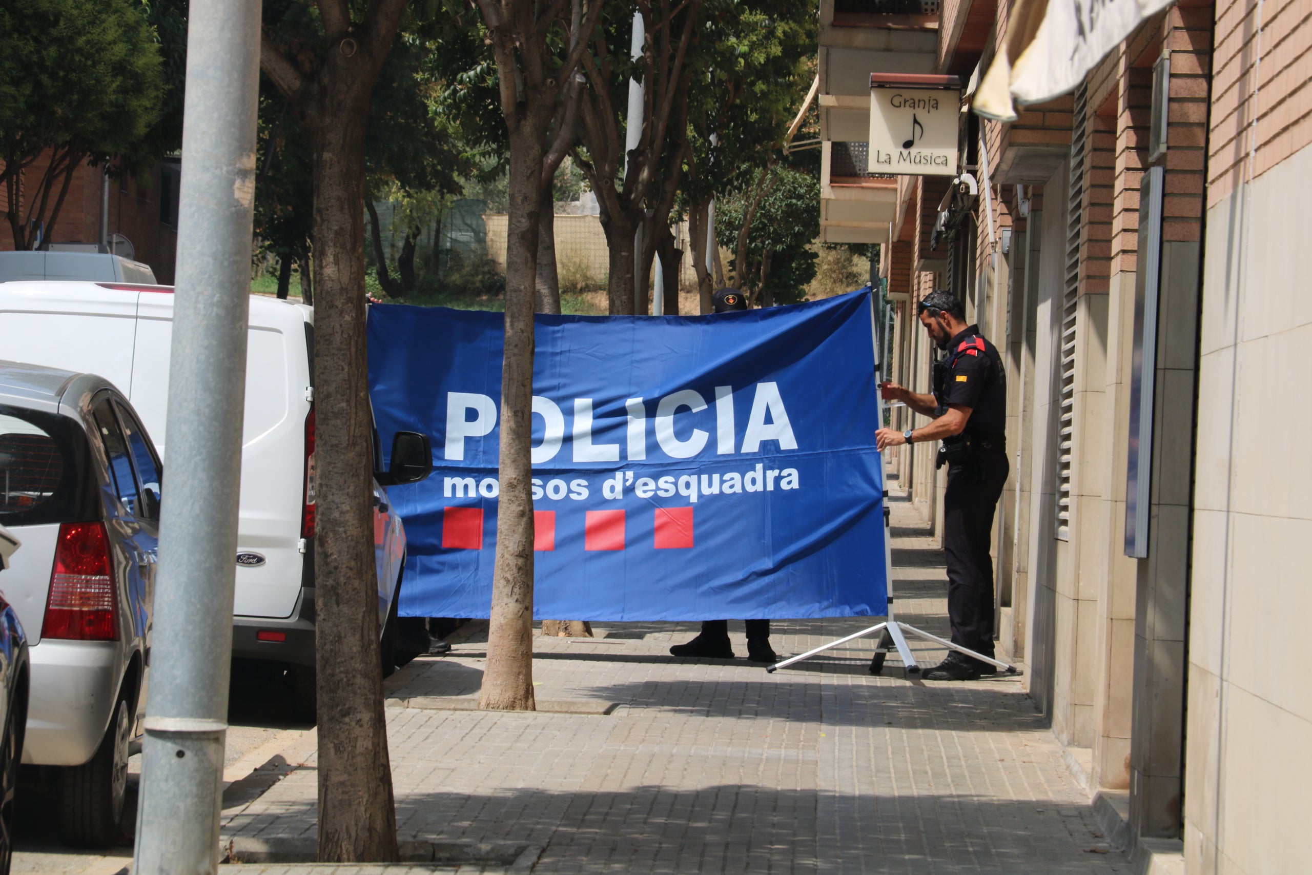 Els Mossos posen una lona davant l'edifici on s'han comès els fets/Àlex Recolons-ACN