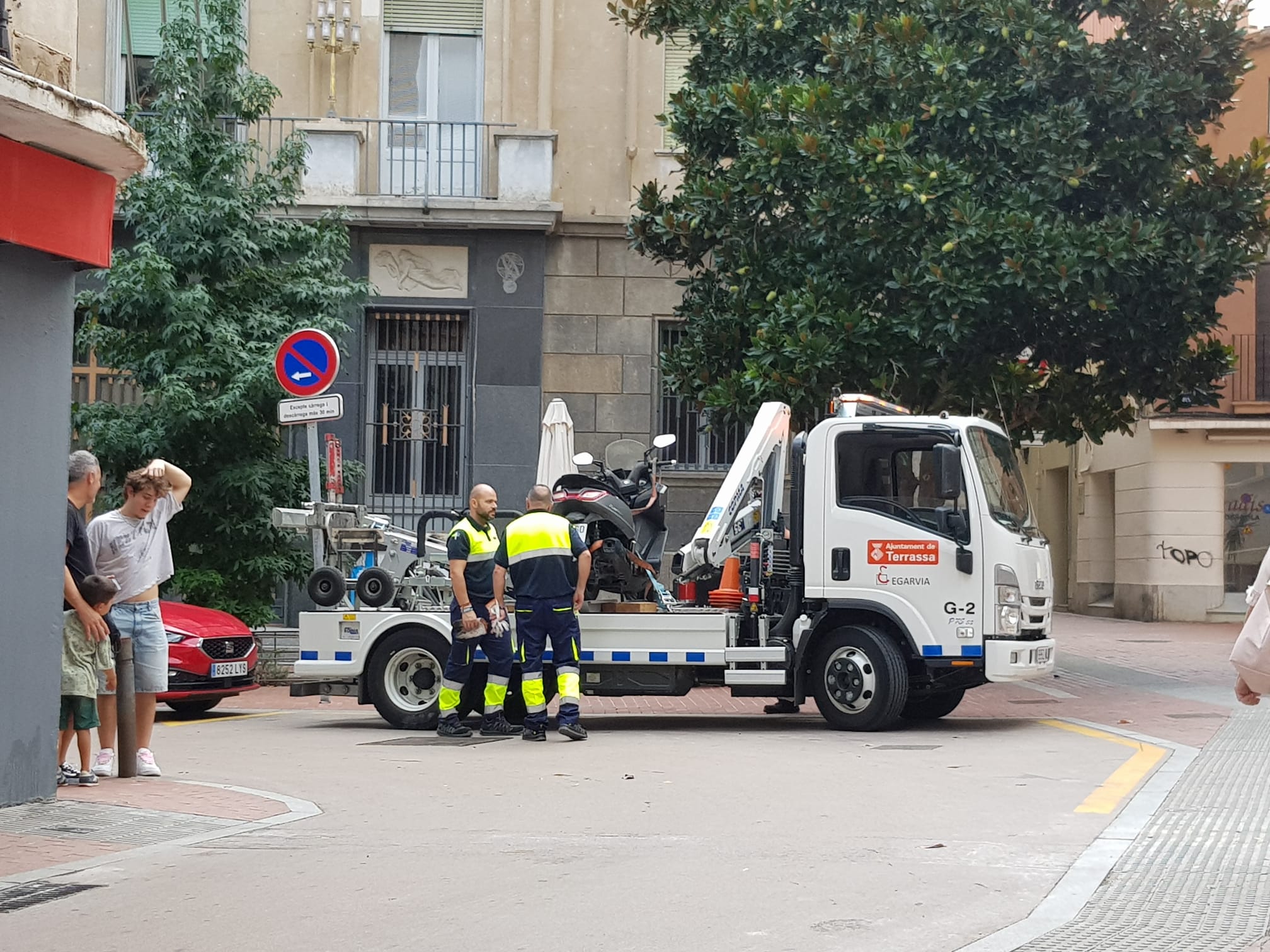 Grua municipal enduent-se una moto que estava aparcada a la vorera | Lluïsa Tarrida