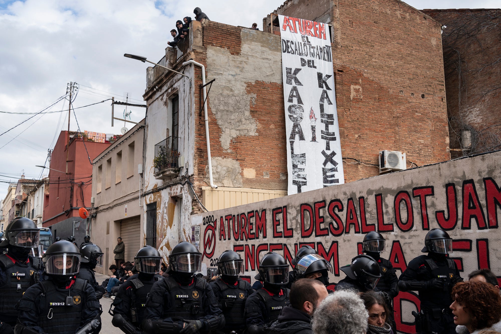 Aquest dimarts, dia 25 de març, s’ha produït el desallotjament del Kasalet i del Kalitxet a Terrassa. Hi ha hagut un amplíssim dispositiu dels Mossos d’Esquadra, que ha bloquejat el pas de vianants i vehicles durant més de dues hores la zona de la placeta de la Creu Gran, en ple Centre de la ciutat. Els membres dels centres okupats han ofert una resistència passiva, col·locant-se davant de les portes d’accés i obligant als agents a arrencar-los un a un. Finalment, han pogut rebentar les dues portes i entrar als edificis, i s’han identificat sis persones.