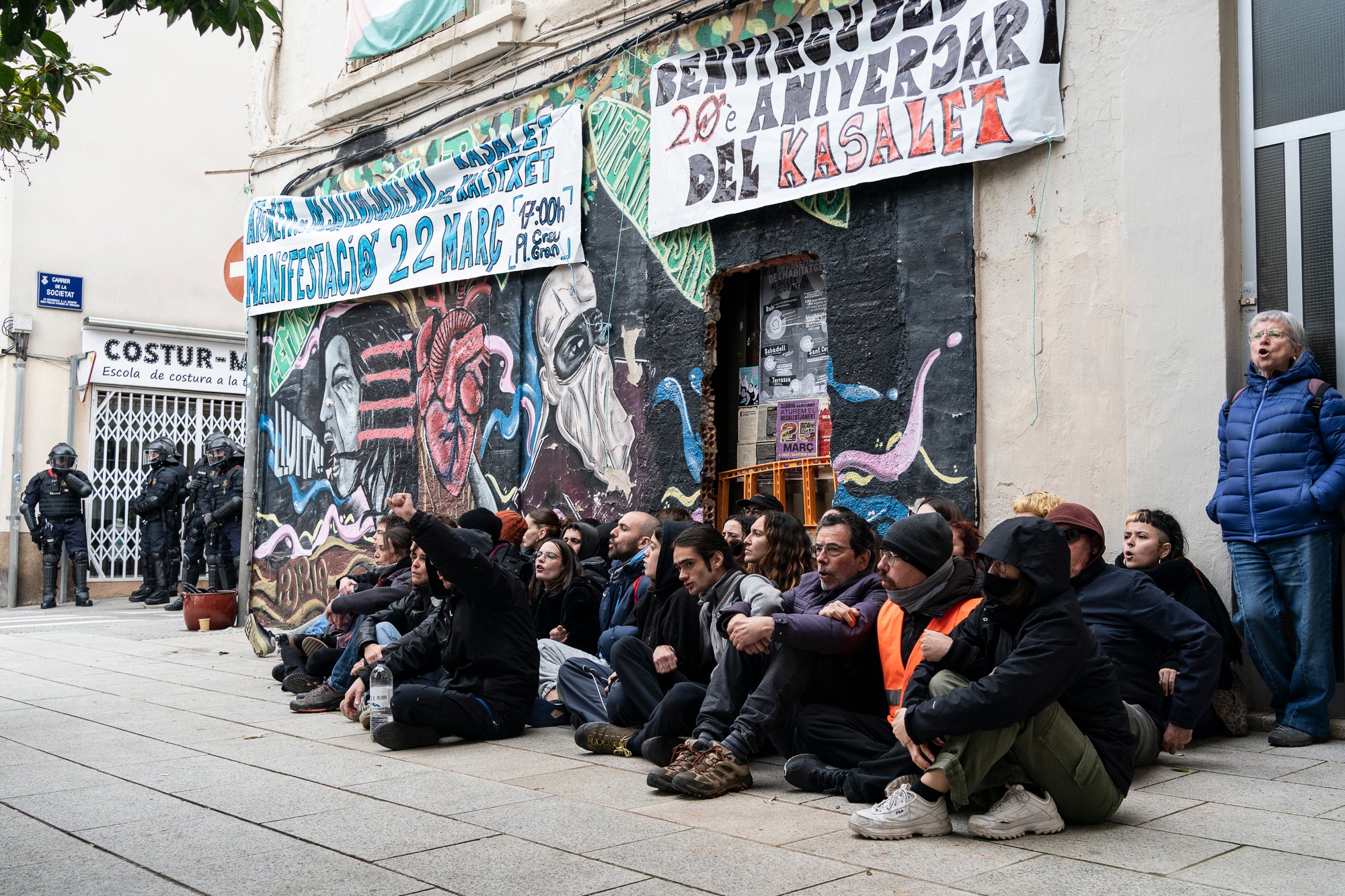 Aquest dimarts, dia 25 de març, s’ha produït el desallotjament del Kasalet i del Kalitxet a Terrassa. Hi ha hagut un amplíssim dispositiu dels Mossos d’Esquadra, que ha bloquejat el pas de vianants i vehicles durant més de dues hores la zona de la placeta de la Creu Gran, en ple Centre de la ciutat. Els membres dels centres okupats han ofert una resistència passiva, col·locant-se davant de les portes d’accés i obligant als agents a arrencar-los un a un. Finalment, han pogut rebentar les dues portes i entrar als edificis, i s’han identificat sis persones.