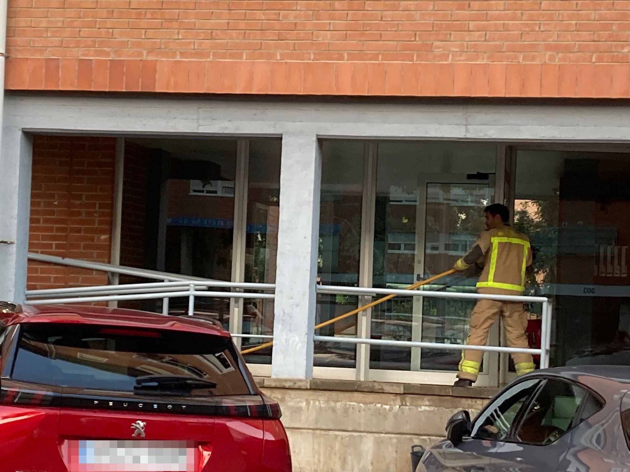 Els Bombers netejant el portal on va cremar el patinet | Santiago Carrasco