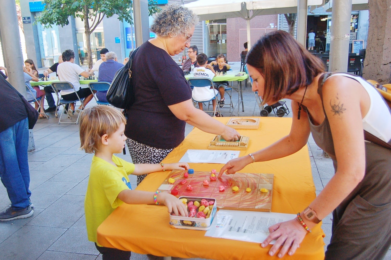 Aquesta setmana, fins al dia 5 de setembre, la plaça Vapor Ventalló acull la 9a edició de la Setmana de Jocs al Carrer, organitzada per l’Associació Terrassenca de Jocs – Vadejoc. Aquesta iniciativa vol acostar el joc a l’espai públic, vol fomentar la participació familiar i la cohesió social a través d’activitats gratuïtes i inclusives. Al llarg de cinc dies, la plaça s’omple de jocs tradicionals, jocs de taula, jocs d’habilitat i tallers de joguines. A més, com a novetat, enguany tenim un campionat del joc de la botifarra o la presentació de nous jocs creats a Terrassa. Cada jornada es tanca amb una sessió de contacontes a càrrec de l’Associació Vet Aquí Que.