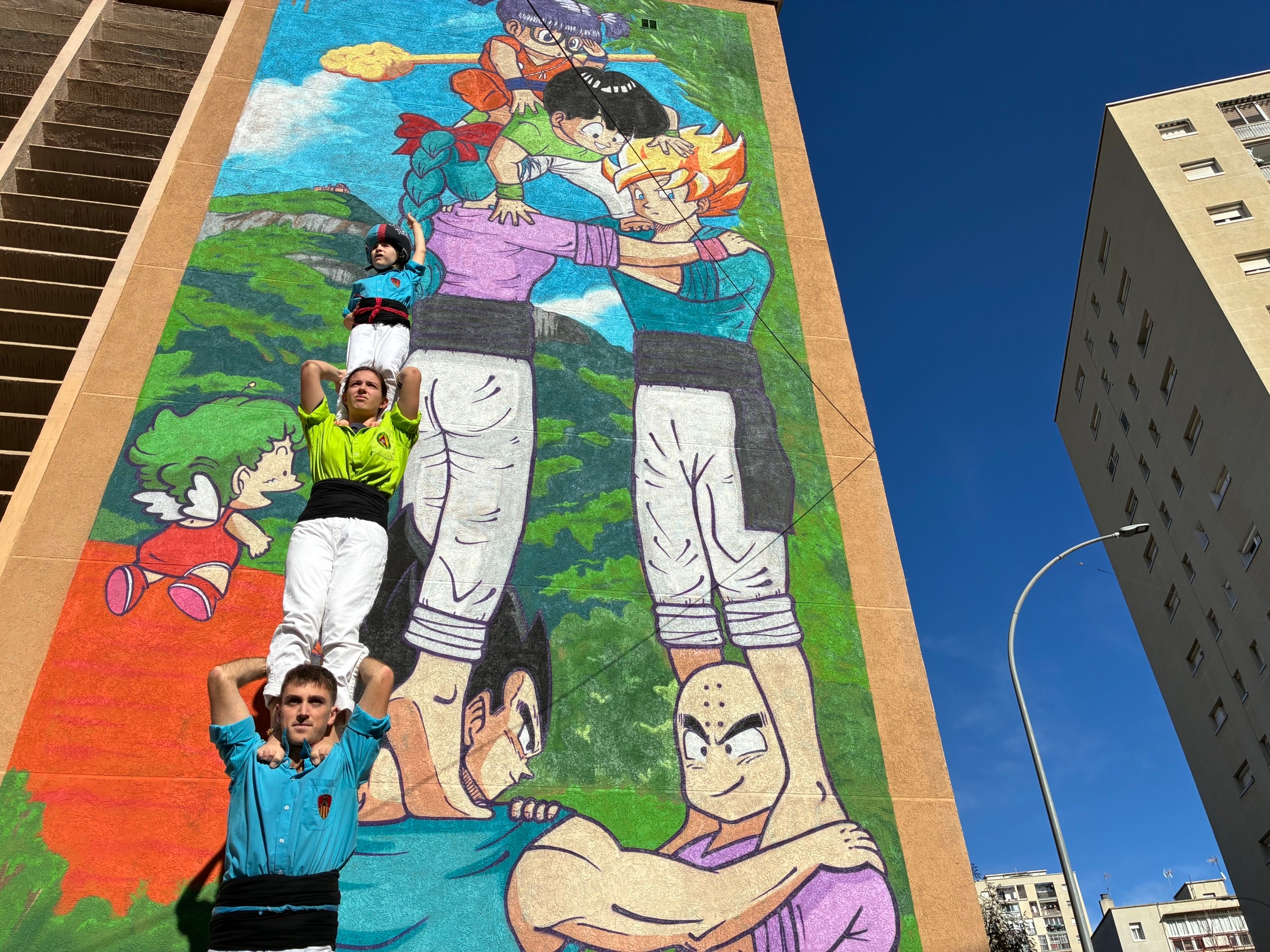 Membres dels Castellers i els Bergants de Terrassa en un pilar de quatre per inaugurar el mural d'homenatge a Toriyama al barri de Sant Llorenç de Terrassa | Vicenç Batalla