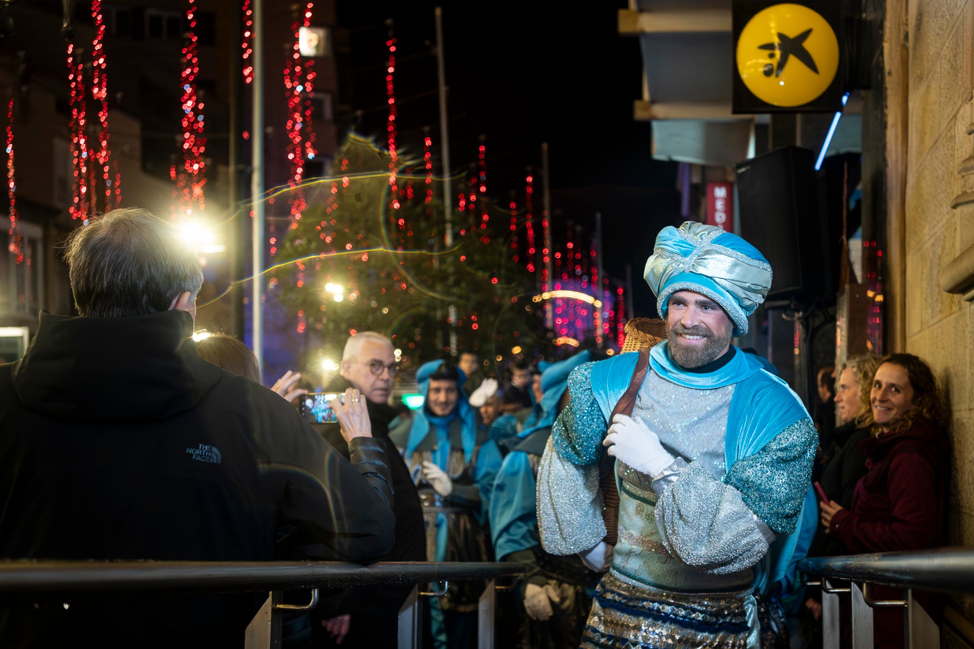 Malgrat unes condicions meteorològiques adverses, que han obligat a canviar l'itinerari de la corrua anant en trenet des de l'Estació del Nord i impedint que els Gegants de Terrassa poguessin acompanyar-lo baixant pel carrer de la Font Vella i es fes el Ball de l'Àliga al final, el patge Xiu-Xiu ha tingut la grata sorpresa a la seva arribada al Raval de Montserrat de trobar-se amb el seu capgròs com a regal pel seu 75 aniversari. Obra de l'artesà Jan Grau, el patge també compta a partir d'ara amb la seva figureta al pessebre oficial davant de l'Ajuntament. I des d'aquest dissabte i fins al 5 de gener, recorrerà els barris de la ciutat per recollir les cartes als Reis dels nens i nenes que s'hagin portat bé | Mireia Comas