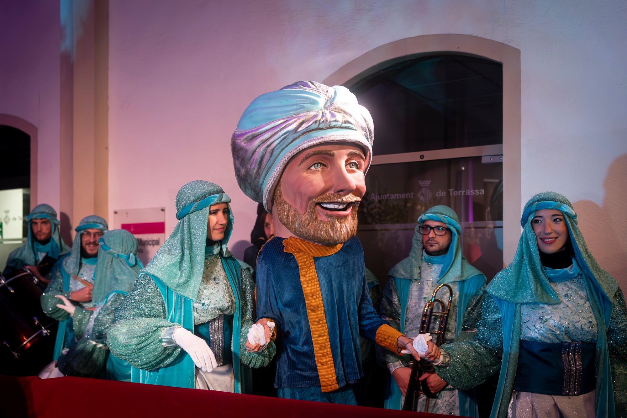 Malgrat unes condicions meteorològiques adverses, que han obligat a canviar l'itinerari de la corrua anant en trenet des de l'Estació del Nord i impedint que els Gegants de Terrassa poguessin acompanyar-lo baixant pel carrer de la Font Vella i es fes el Ball de l'Àliga al final, el patge Xiu-Xiu ha tingut la grata sorpresa a la seva arribada al Raval de Montserrat de trobar-se amb el seu capgròs com a regal pel seu 75 aniversari. Obra de l'artesà Jan Grau, el patge també compta a partir d'ara amb la seva figureta al pessebre oficial davant de l'Ajuntament. I des d'aquest dissabte i fins al 5 de gener, recorrerà els barris de la ciutat per recollir les cartes als Reis dels nens i nenes que s'hagin portat bé | Mireia Comas