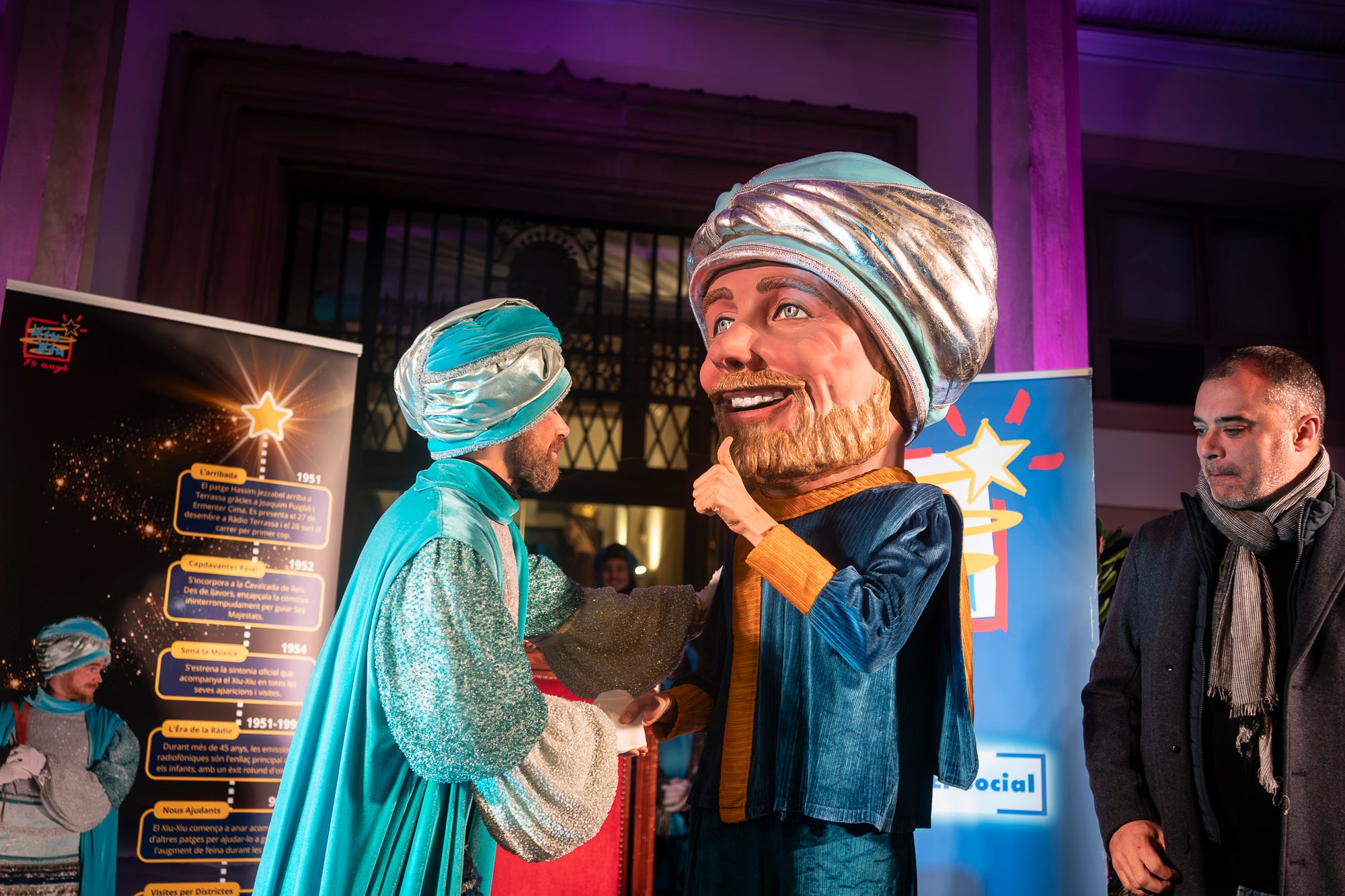 Malgrat unes condicions meteorològiques adverses, que han obligat a canviar l'itinerari de la corrua anant en trenet des de l'Estació del Nord i impedint que els Gegants de Terrassa poguessin acompanyar-lo baixant pel carrer de la Font Vella i es fes el Ball de l'Àliga al final, el patge Xiu-Xiu ha tingut la grata sorpresa a la seva arribada al Raval de Montserrat de trobar-se amb el seu capgròs com a regal pel seu 75 aniversari. Obra de l'artesà Jan Grau, el patge també compta a partir d'ara amb la seva figureta al pessebre oficial davant de l'Ajuntament. I des d'aquest dissabte i fins al 5 de gener, recorrerà els barris de la ciutat per recollir les cartes als Reis dels nens i nenes que s'hagin portat bé | Mireia Comas