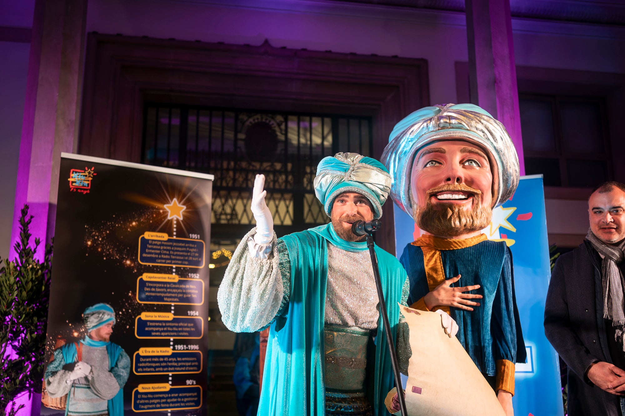 Malgrat unes condicions meteorològiques adverses, que han obligat a canviar l'itinerari de la corrua anant en trenet des de l'Estació del Nord i impedint que els Gegants de Terrassa poguessin acompanyar-lo baixant pel carrer de la Font Vella i es fes el Ball de l'Àliga al final, el patge Xiu-Xiu ha tingut la grata sorpresa a la seva arribada al Raval de Montserrat de trobar-se amb el seu capgròs com a regal pel seu 75 aniversari. Obra de l'artesà Jan Grau, el patge també compta a partir d'ara amb la seva figureta al pessebre oficial davant de l'Ajuntament. I des d'aquest dissabte i fins al 5 de gener, recorrerà els barris de la ciutat per recollir les cartes als Reis dels nens i nenes que s'hagin portat bé | Mireia Comas