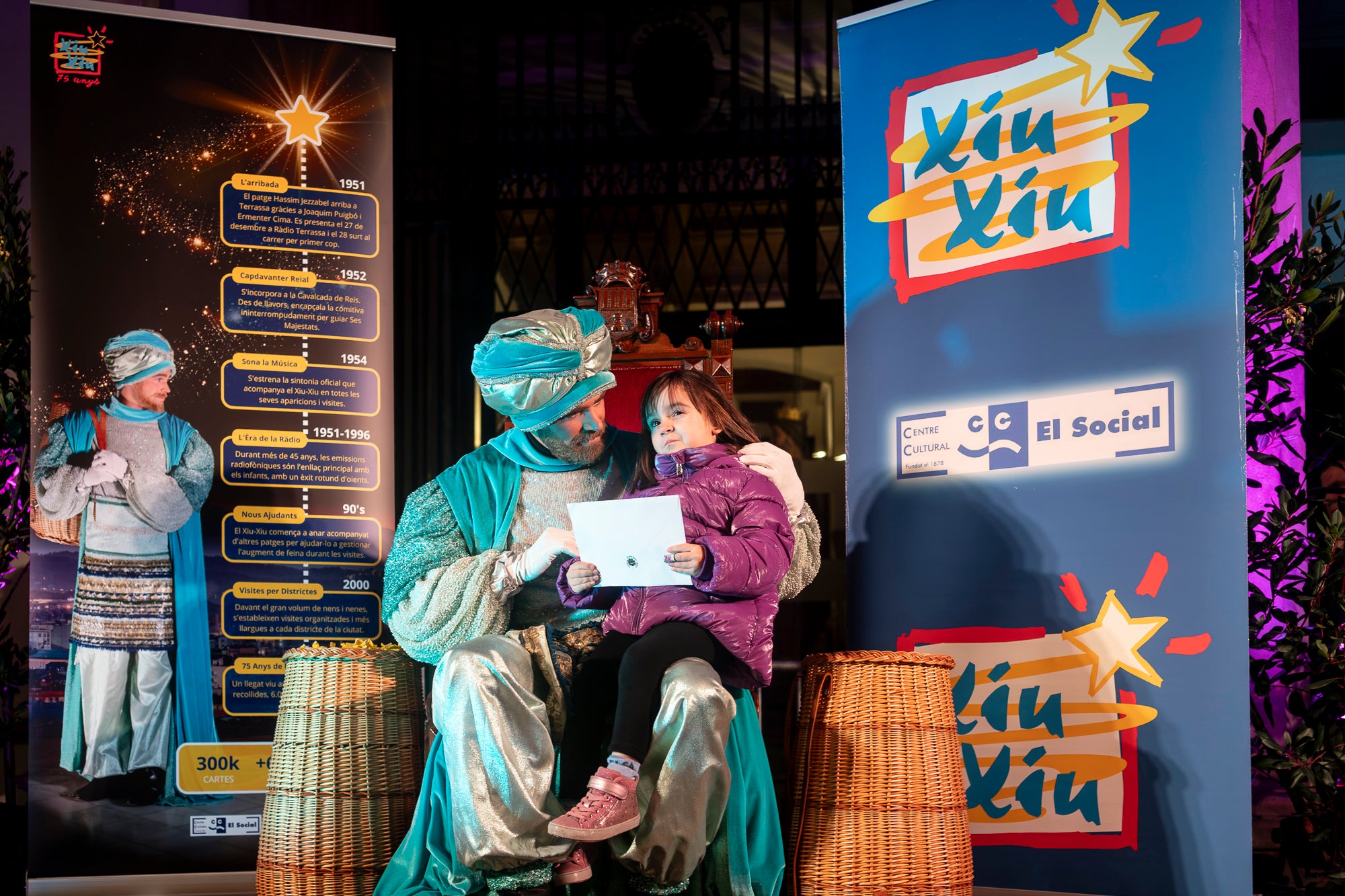 Malgrat unes condicions meteorològiques adverses, que han obligat a canviar l'itinerari de la corrua anant en trenet des de l'Estació del Nord i impedint que els Gegants de Terrassa poguessin acompanyar-lo baixant pel carrer de la Font Vella i es fes el Ball de l'Àliga al final, el patge Xiu-Xiu ha tingut la grata sorpresa a la seva arribada al Raval de Montserrat de trobar-se amb el seu capgròs com a regal pel seu 75 aniversari. Obra de l'artesà Jan Grau, el patge també compta a partir d'ara amb la seva figureta al pessebre oficial davant de l'Ajuntament. I des d'aquest dissabte i fins al 5 de gener, recorrerà els barris de la ciutat per recollir les cartes als Reis dels nens i nenes que s'hagin portat bé | Mireia Comas