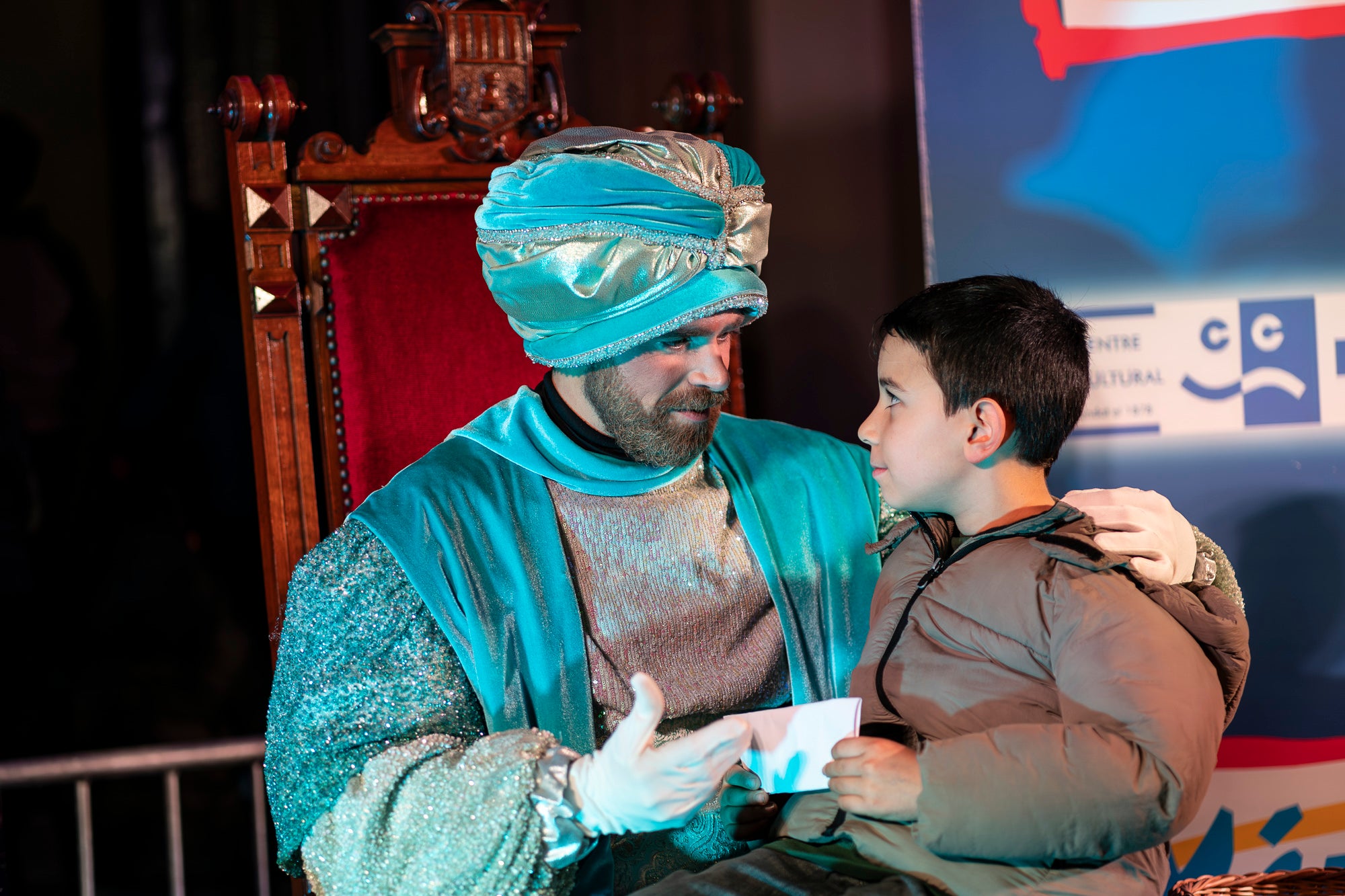 Malgrat unes condicions meteorològiques adverses, que han obligat a canviar l'itinerari de la corrua anant en trenet des de l'Estació del Nord i impedint que els Gegants de Terrassa poguessin acompanyar-lo baixant pel carrer de la Font Vella i es fes el Ball de l'Àliga al final, el patge Xiu-Xiu ha tingut la grata sorpresa a la seva arribada al Raval de Montserrat de trobar-se amb el seu capgròs com a regal pel seu 75 aniversari. Obra de l'artesà Jan Grau, el patge també compta a partir d'ara amb la seva figureta al pessebre oficial davant de l'Ajuntament. I des d'aquest dissabte i fins al 5 de gener, recorrerà els barris de la ciutat per recollir les cartes als Reis dels nens i nenes que s'hagin portat bé | Mireia Comas