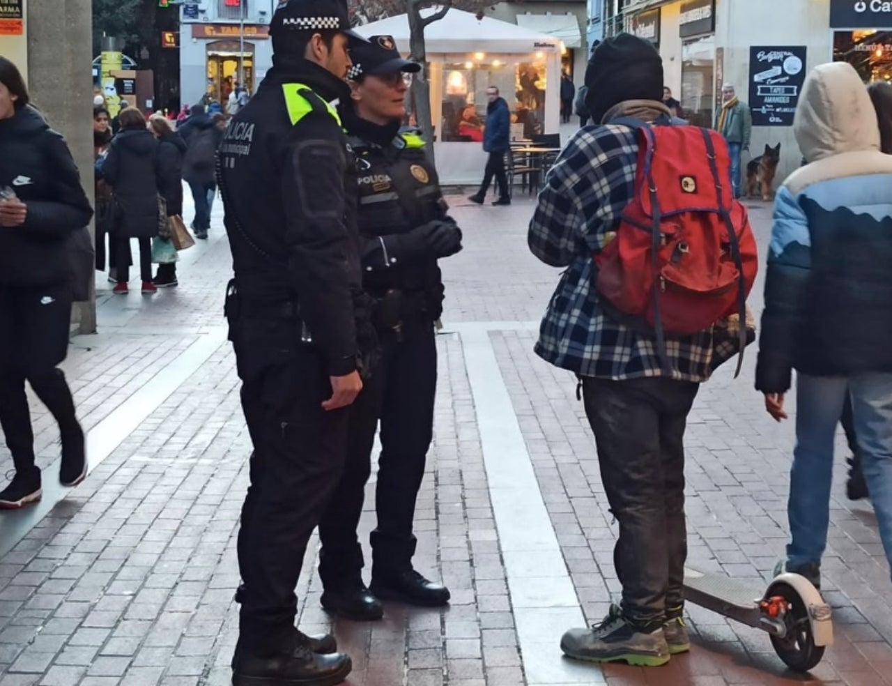 Una dotació de la Policia Municipal de Terrassa parlant amb el conductor d'un patinet elèctric | PMT