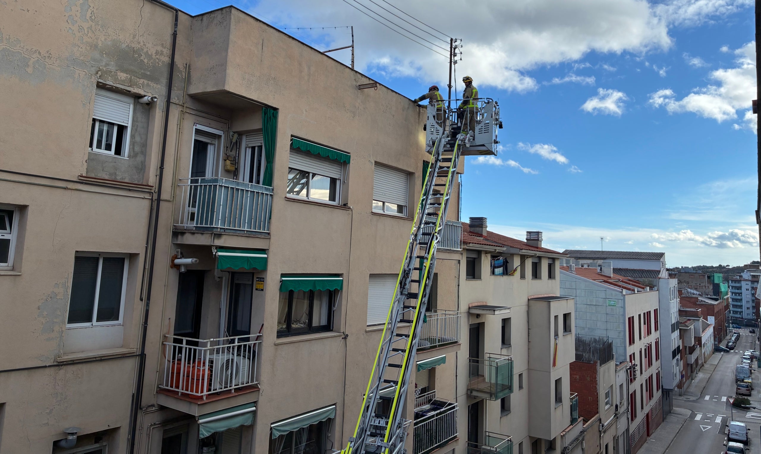 Intervenció al carrer Galvani de Ca n'Aurell de Terrassa per reparar l'arrebossat d'una façana que queia a causa del vent aquest diumenge | Vicenç Batalla