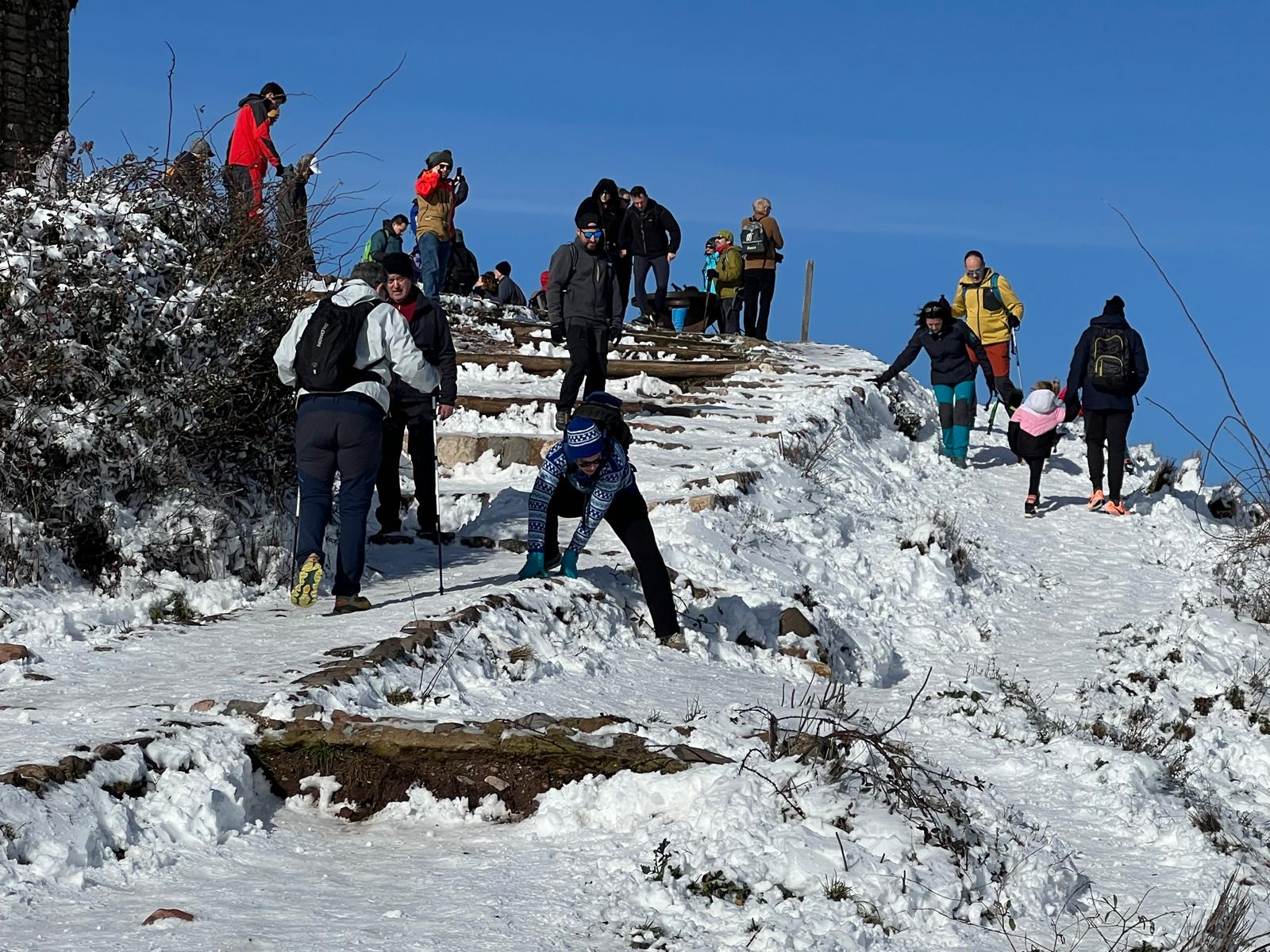 Els excursionistes no s'han volgut perdre l'experiència de pujar al cim de La Mola del Parc Natural de Sant Llorenç del Munt l'endemà d'una gran nevada, la segona d'aquest gener del 2026, aprofitant que el dia és fred però ben assolellat. Ben equipats, a causa precisament de la neu, en els últims trams de l'arribada al monestir s'havia de vigilar de no ensopegar. Però una vegada a dalt, les vistes també nevades de tot l'entorn pagaven la pena | Jordi Roset/Salvador Cot