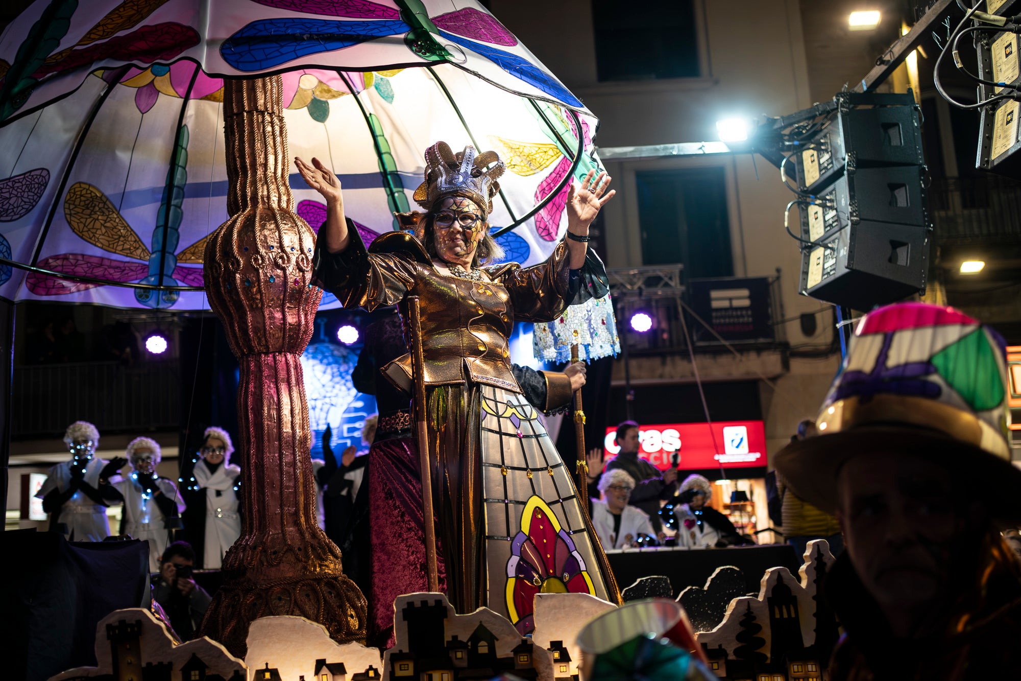 Els carrers de Terrassa s'han disfressat aquest dissabte al vespre per a una rua de Carnestoltes 2026 multitudinària, partint de la plaça de les Magnòlies, en què hi han participat 25 carrosses amb 2.189 persones. Ha obert la comparsa 'Groc cridaner', guanyadora de la desfilada l'any passat, on figuraven la reina i el rei d'enguany, Tifarola i Tifanal. Al cap d'unes hores, rebien les claus de la ciutat durant aquests dies de disbauxa des del balcó de l'Ajuntament, al Raval. Allà, hi han pronunciat un pregó combatiu les membres de lila del Casal de la Dona, en què han reivindicat 'cossos lliures' i una festa 'feminista, irreverent i republicana'. | Mireia Comas