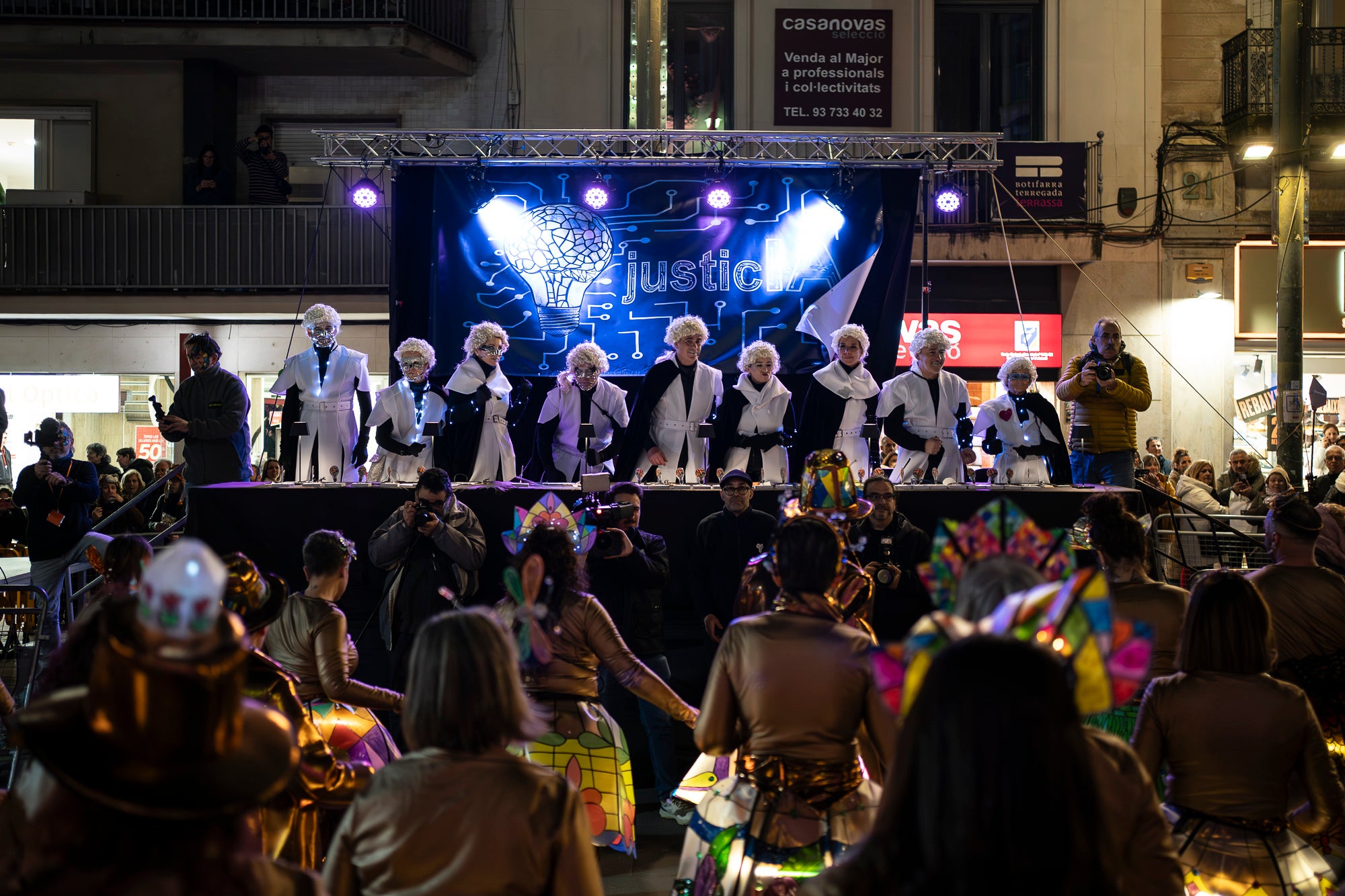 Els carrers de Terrassa s'han disfressat aquest dissabte al vespre per a una rua de Carnestoltes 2026 multitudinària, partint de la plaça de les Magnòlies, en què hi han participat 25 carrosses amb 2.189 persones. Ha obert la comparsa 'Groc cridaner', guanyadora de la desfilada l'any passat, on figuraven la reina i el rei d'enguany, Tifarola i Tifanal. Al cap d'unes hores, rebien les claus de la ciutat durant aquests dies de disbauxa des del balcó de l'Ajuntament, al Raval. Allà, hi han pronunciat un pregó combatiu les membres de lila del Casal de la Dona, en què han reivindicat 'cossos lliures' i una festa 'feminista, irreverent i republicana'. | Mireia Comas