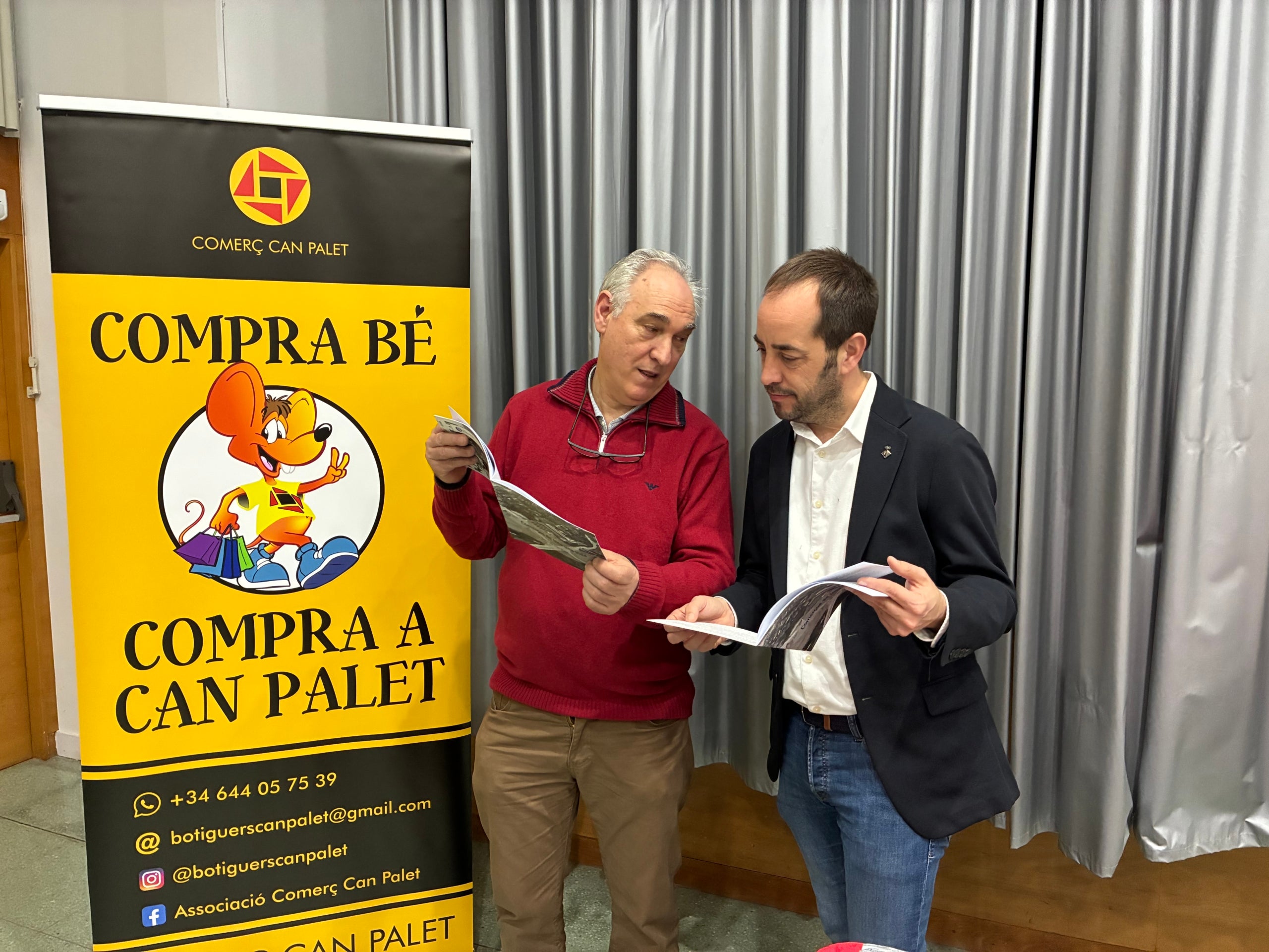 El president de Comerç Can Palet, Francisco Viciana, amb el regidor de Comerç, Xavier Cardona, comentant el llibre 'Comerços de tota una vida' del barri | Vicenç Batalla