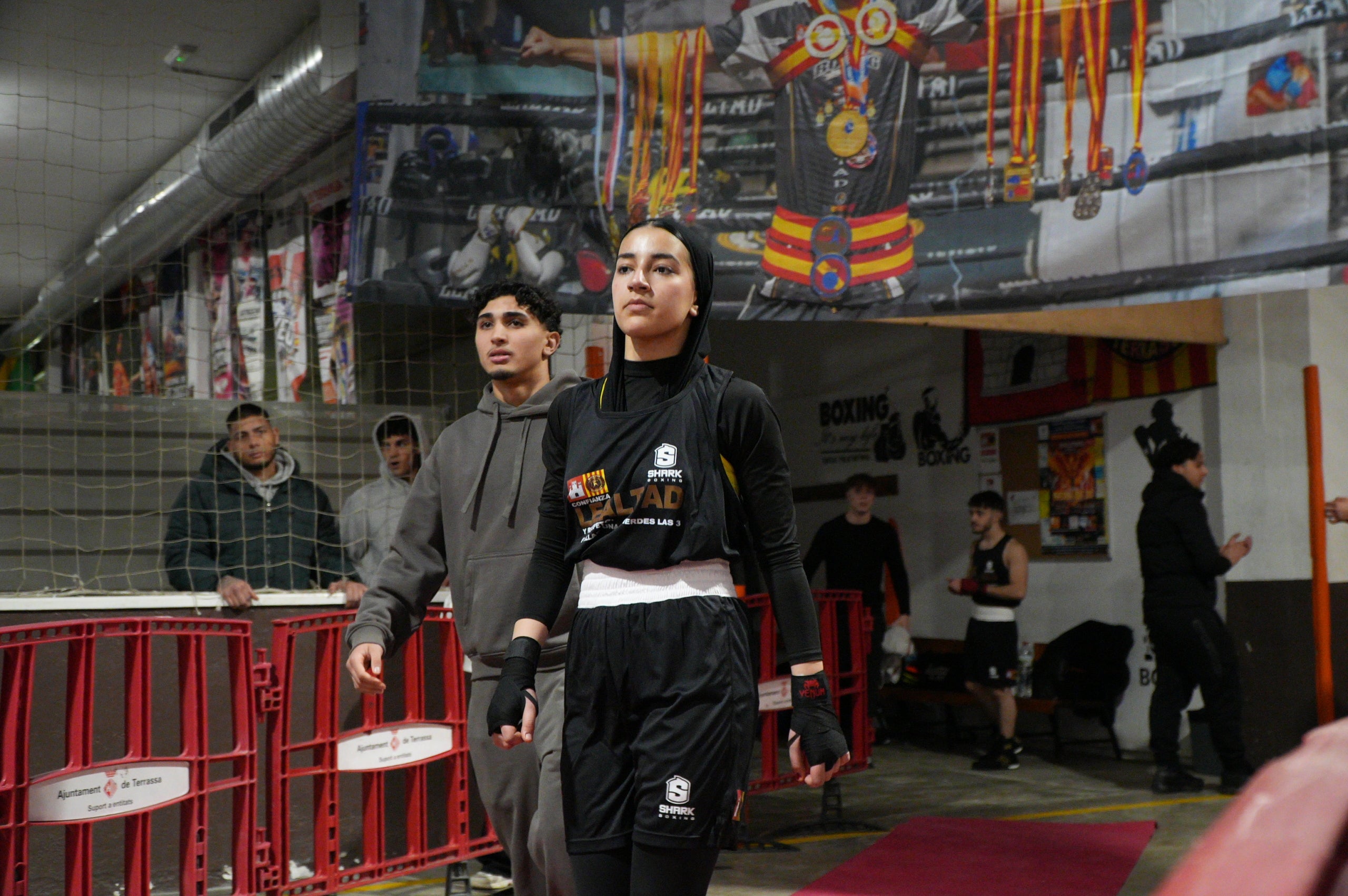 Gran jornada de boxa al pavelló poliesportiu de La Cogullada. El Boxing Club Terrassa va preparar un dissabte ple de lluita i passió amb un total de dotze combats de totes les categories. Era la prèvia perfecte per acompanyar el debut com a professional de Musta Jr. L’esdeveniment va crear molta expectació i els boxejadors de Terrassa van demostrar el seu nivell davant d’un públic entregat. Van competir: els juniors Adam IBN Maimoun, Hanna Al Fakiri, Rafael El Kasser (del Boxing Terrassa) i Solaiman Rouaz (del Team S. Leon), els joves Emma Méndez, Gerard Martín i Achraf El Idrissi (del Boxing) i David Sánchez (del Team S. Leon); i en elit, Pedro Martinez (Boxing). A més, es va fer un reconeixement especial al terrassenc Fran Garcia, actual campió d’Espanya en boxa adaptada.