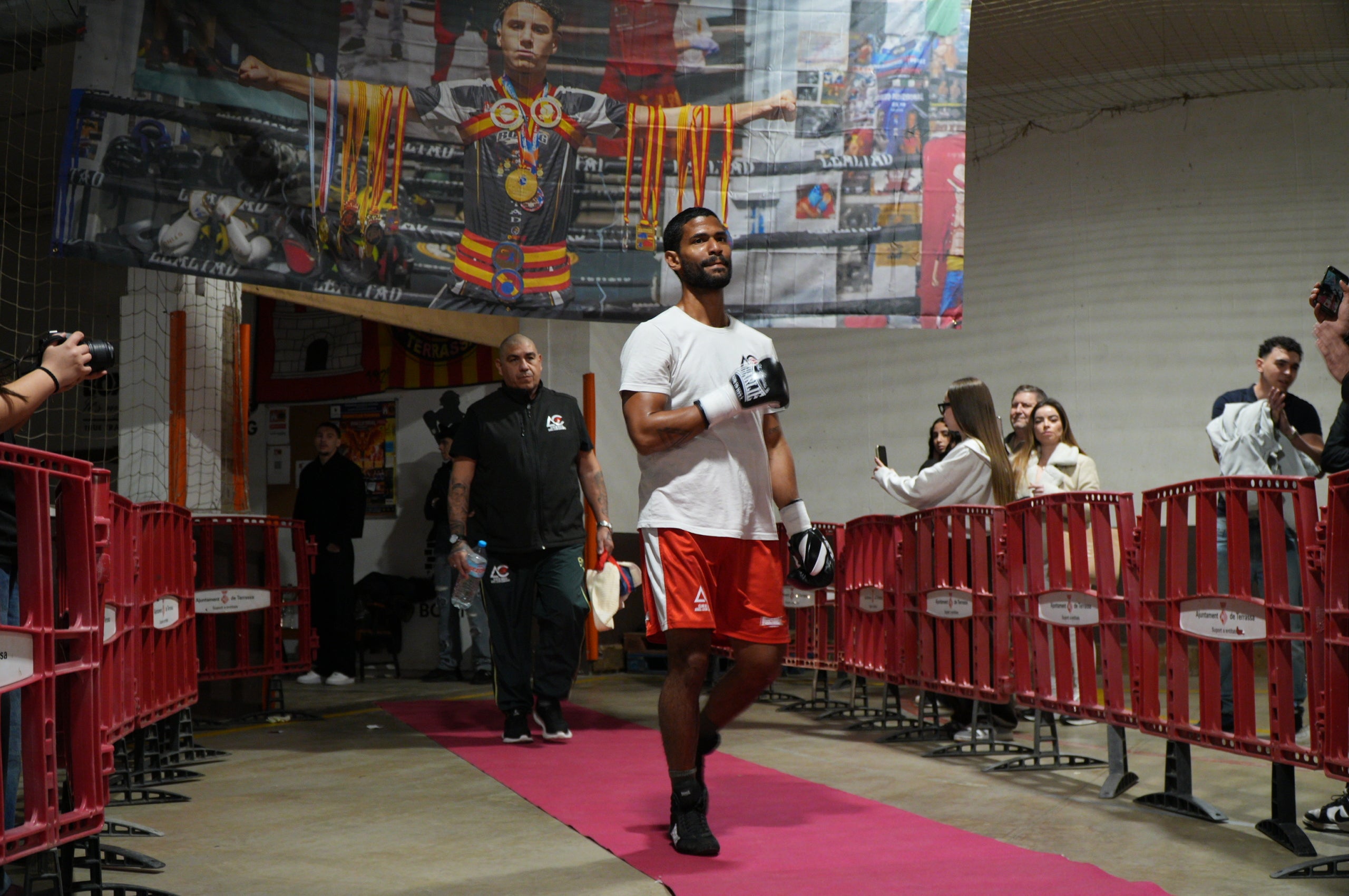 Nit molt especial a La Cogullada amb l’estrena com professional del boxejador terrassenc Musta Jr. El “rei” ha fet un pas endavant després de triomfar en les categories amateurs, aconseguint títols i medalles estatals i internacionals. Aquest dissabte, ha estat el dia escollit per debutar, i ho ha fet davant d’un rival que no era fàcil, el colombià Jorge Luna, amb tretze combats ja com a professional. Musta Jr no ha decebut i s’ha imposat per 1-0-0 (1KO). Autèntica bogeria al pavelló poliesportiu de Terrassa per celebrar el primer triomf de molts per a la jove promesa de la boxa.