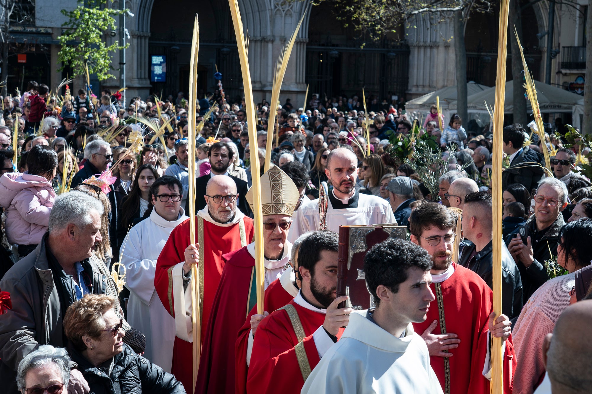Un any més, el Diumenge de Rams ha estat el moment de la benedicció de les palmes aquest migdia per part del bisbe de Terrassa, Salvador Cristau, que ha pronunciat unes paraules acompanyat del seu seguici en una plaça Vella ben plena en un dia assolellat. Després, s'ha dirigit a la catedral del Sant Esperit on s'ha celebrat la missa que dona pas a la resta de la Setmana Santa | Mireia Comas