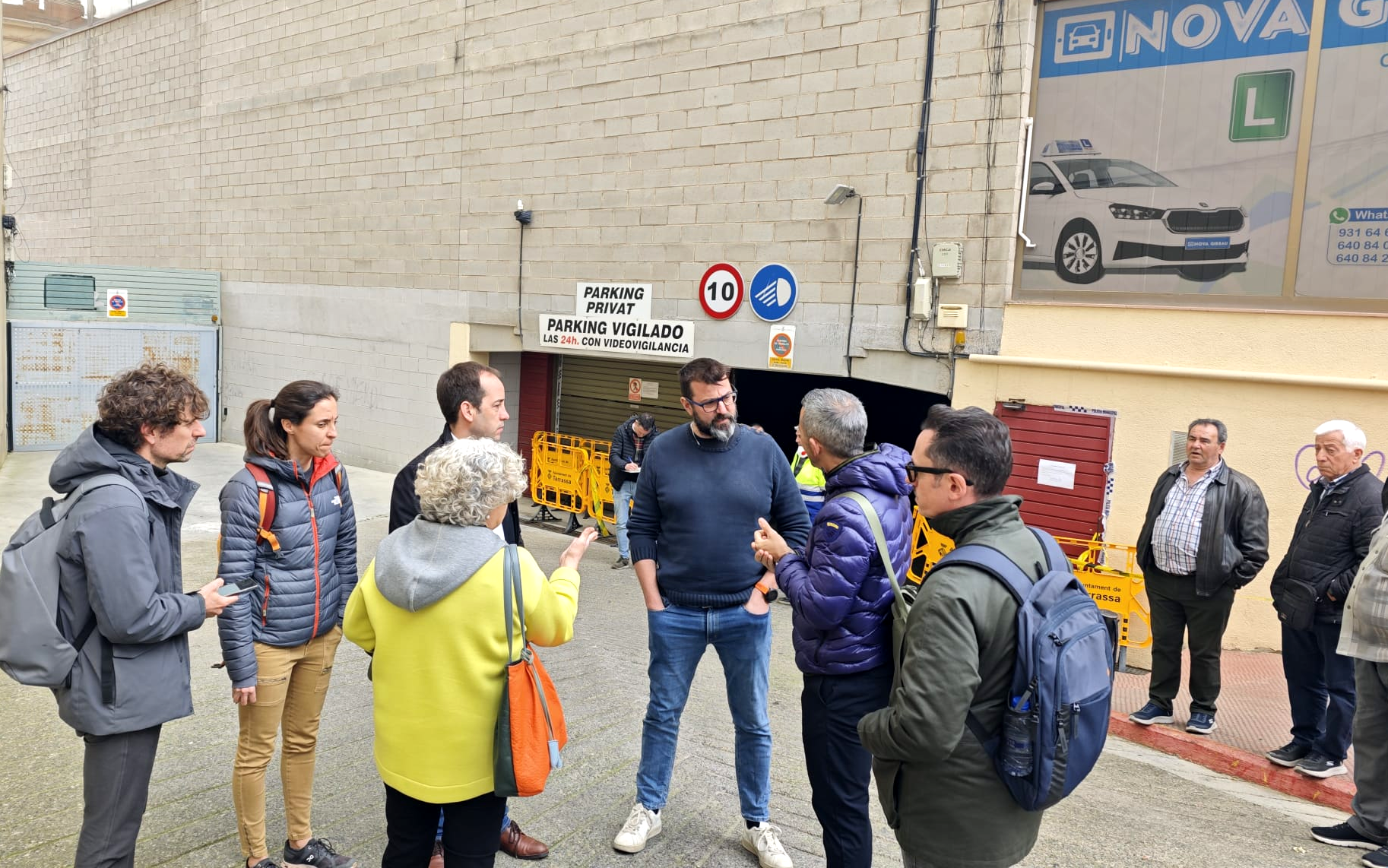 El regidor de Mobilitat de Terrassa, Xavier Cardona, enmig, escoltant els propietaris afectats per l'incendi a l'aparcamcent del mercat de Can Boada, acompanyat de tècnics municipals aquest dilluns | Aj. Terrassa