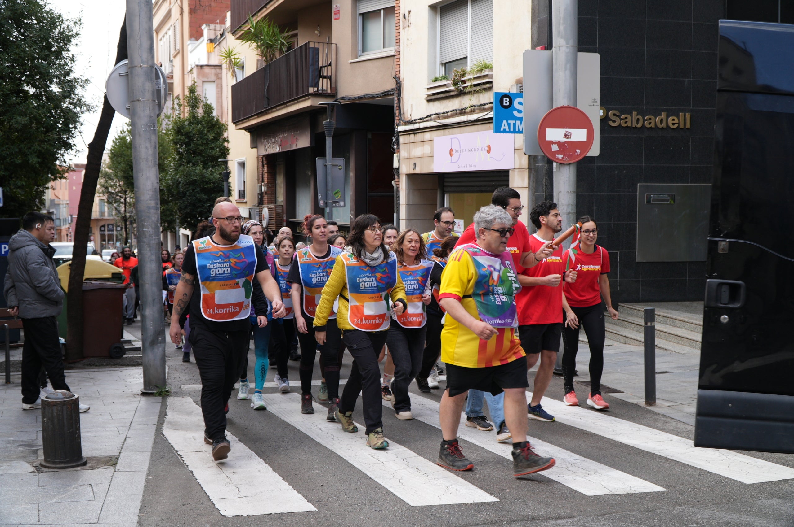 La plaça del Vapor Ventalló i els seus voltants, al centre de Terrassa, van ser l'escenari aquest dissabte de la segona edició local de la Korrika, una cursa que es fa cada dos anys al País Basc des del 1980 per reivindicar l'ús de l'euskera. I que, en la versió terrassenca, s'estén a l'ús del català i altres llengües minoritzades. Al matí, grups de totes les edats van córrer per aquests cèntrics carrers abans que al migdia hi hagués un acte polític amb la participació d'integrants de l'AEK, coordinadora per a alfabetitzar i euskaldunitzar a la població. I també de membres de la Plataforma per la Llengua, Català a Terrassa, Òmnium Cultural, Correllengua i el moviment feminista de la ciutat. I, a partir d'aquí i amb interpretació de cançons tradicionals basques, va ser el torn per a un pintxo pote, un dinar amb paella, el concert d'Uralita i una fi de festa de ball | Jan Romero