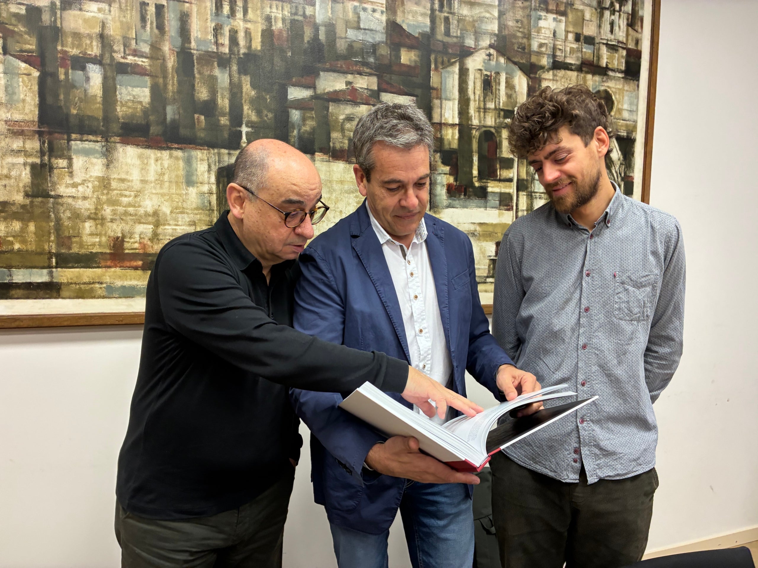 L'empresari tèxtil Jordi Dinarès, el president de l'Institut Industrial, Francesc Roca, i l'historiador Albert Amat fullejant el llibre dels 150 anys de la institució | Vicenç Batalla