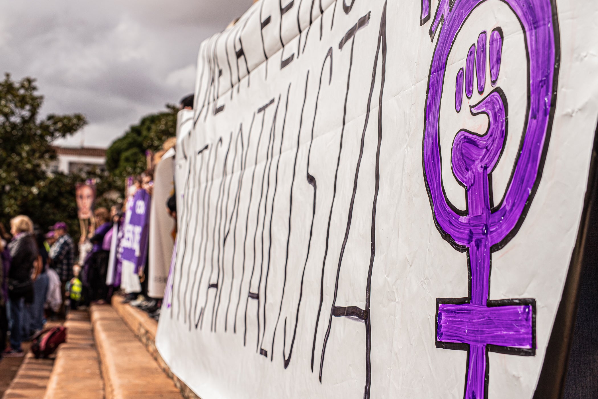 Per primera vegada, aquest 2026 la manifestació del 8M no ha acabat al Raval de Montserrat davant de l'Ajuntament de Terrassa sinó als simbòlics Jardins d'Eva Abad, a Torre-sana, en homenatge a la metgessa assassinada el 2019. Des de la plaça de la Dona, la desfilada feminista d'aquest any ha baixat per l'avinguda de Barcelona per girar cap a l'est i anar a la plaça de Ca n'Anglada, coneguda com 'la Roja' durant el franquisme, on s'ha llegit el manifest '50 anys de feminisme i la lluita continua!' i hi ha hagut altres parlaments. Entre la desena d'entitats, encapçalades pel Casal de la Dona, que enguany compleix 40 anys, n'hi havia més d'una de barris però també les anticapitalistes Rudes Rebels. La desfilada ha acabat entonant les cançons 'Les criades' i 'Cant de lluita' | Javi Sánchez