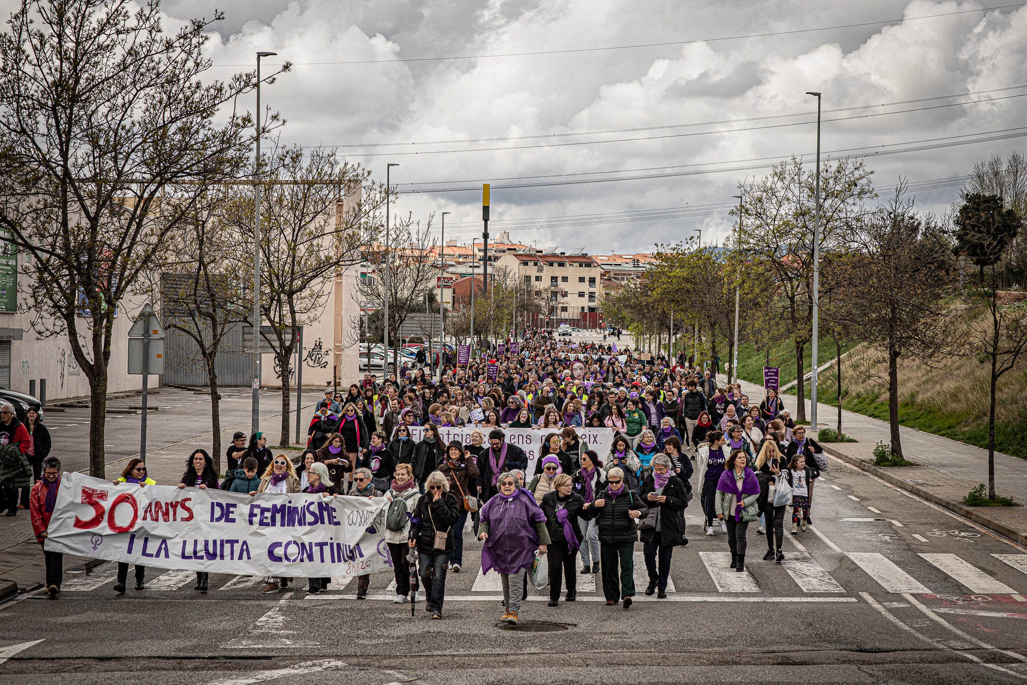 Per primera vegada, aquest 2026 la manifestació del 8M no ha acabat al Raval de Montserrat davant de l'Ajuntament de Terrassa sinó als simbòlics Jardins d'Eva Abad, a Torre-sana, en homenatge a la metgessa assassinada el 2019. Des de la plaça de la Dona, la desfilada feminista d'aquest any ha baixat per l'avinguda de Barcelona per girar cap a l'est i anar a la plaça de Ca n'Anglada, coneguda com 'la Roja' durant el franquisme, on s'ha llegit el manifest 50 anys de feminisme i la lluita continua! i hi ha hagut altres parlaments. Entre la desena d'entitats, encapçalades pel Casal de la Dona, que enguany compleix 40 anys, n'hi havia més d'una de barris però també les anticapitalistes Rudes Rebels. La desfilada ha acabat entonant les cançons Les criades i Cant de lluita | Javi Sánchez