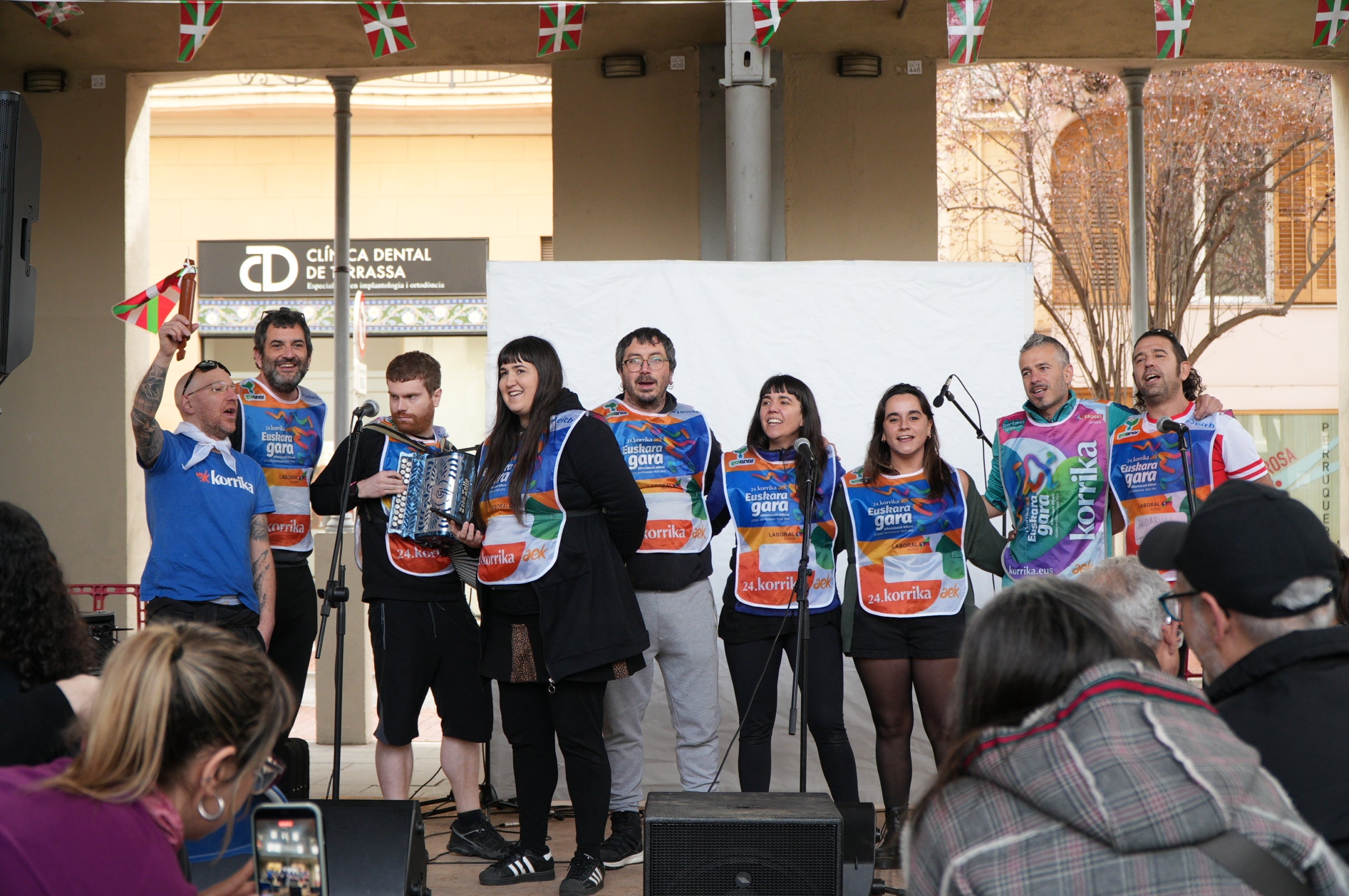 La plaça del Vapor Ventalló i els seus voltants, al centre de Terrassa, van ser l'escenari aquest dissabte de la segona edició local de la Korrika, una cursa que es fa cada dos anys al País Basc des del 1980 per reivindicar l'ús de l'euskera. I que, en la versió terrassenca, s'estén a l'ús del català i altres llengües minoritzades. Al matí, grups de totes les edats van córrer per aquests cèntrics carrers abans que al migdia hi hagués un acte polític amb la participació d'integrants de l'AEK, coordinadora per a alfabetitzar i euskaldunitzar a la població. I també de membres de la Plataforma per la Llengua, Català a Terrassa, Òmnium Cultural, Correllengua i el moviment feminista de la ciutat. I, a partir d'aquí i amb interpretació de cançons tradicionals basques, va ser el torn per a un pintxo pote, un dinar amb paella, el concert d'Uralita i una fi de festa de ball | Jan Romero