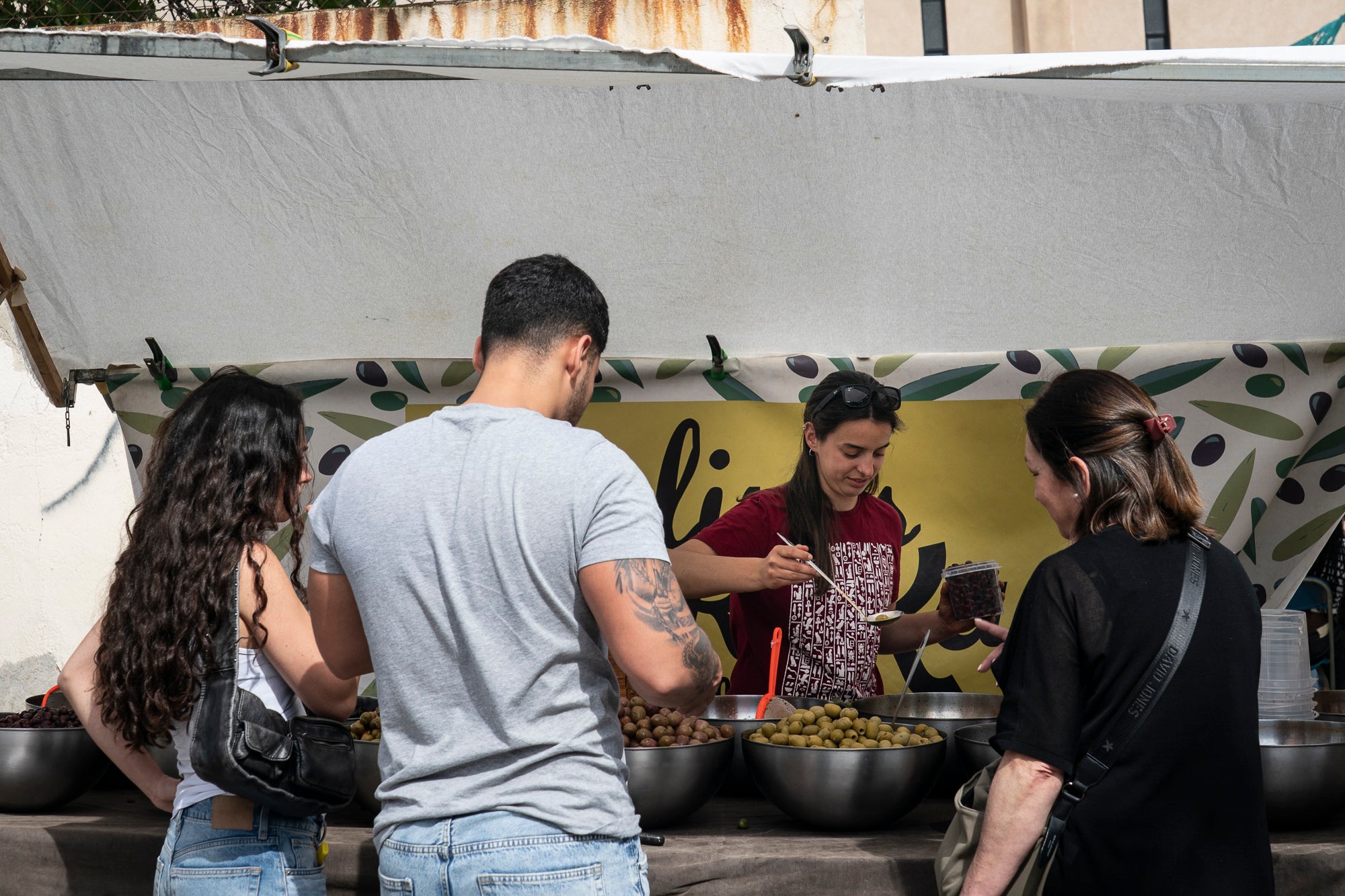 L'onzena Fira de l'Oliva de Ca n'Anglada va celebrar aquest dissabte una jornada completa al voltant de la plaça del barri on el protagonista era, evidentment, el producte derivat de l'arbre indispensable per a la bona gastronomia en les seves versions més artesanals. Hi va haver nombroses parades de productors, entitats i comerços, visites guiades a la masia propera, tallers d'olis aromàtics i el tradicional concurs de llançament de pinyol amb la boca. I, simultàniament, actuacions musicals a càrrec de l'Agrupación San José i el Coro Nazareno o el duo de pop Lua Cheia, entre altres. Alhora, la Ruta de la Tapa per deu bars i restaurants de Ca n'Anglada continua encara fins a aquest diumenge | Mireia Comas