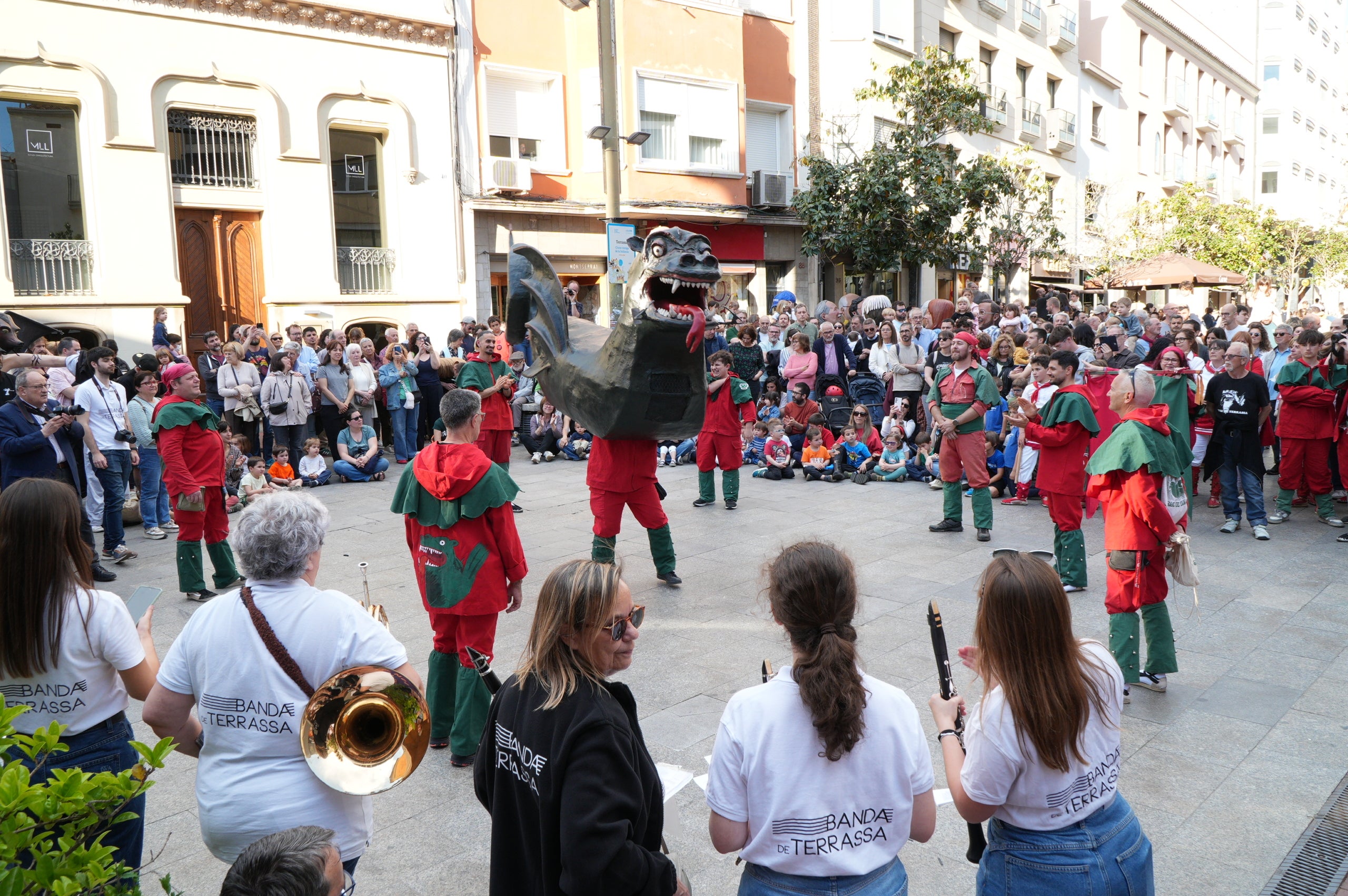 La Banda de Terrassa va celebrar aquest dissabte a la tarda els seus 25 anys d'existència amb una animada cercavila pel centre de la ciutat, en què anaven tocant música per als grups de cultura popular que els acompanyaven i ballaven: Geganters, Bastoners, Ministrils del Raval, Diables, Drac, La Pàjara, Gegants Bojos i Nans i Capgrossos. La comitiva va sortir de la plaça del Vapor Ventalló i va acabar al Raval de Montserrat, davant de l'Ajuntament, on els components de la banda van interpretar un concert final | Jan Romero