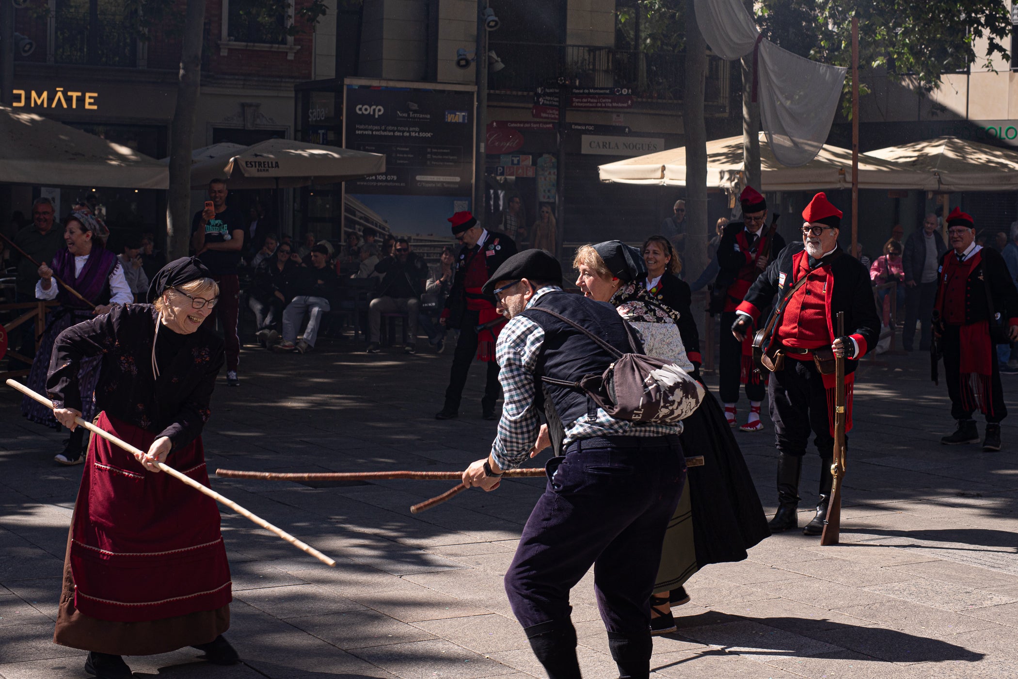 El segon i últim matí d'aquest diumenge de la XXIII Fira Modernista de Terrassa ens porta en aquest recorregut gràfic per les salves dels trabucaires entre carlins i federals, les lluites obreres de la Unió General de Treballadors per unes millors condicions a les empreses tèxtils, una visita com el 1900 al saló de plens de l'Ajuntament amb Farga'm Teatre, artistes, músics i tota mena de personatges d'època. Arrodonit, a la plaça Vella, amb una trobada entre corals, cobla i sardanistes, a càrrec de l'Agrupació Folklòrica Amunt i Crits, ballant al so, entre altres, d'Enric Morera i les lletres de Joan Maragall | Javi González