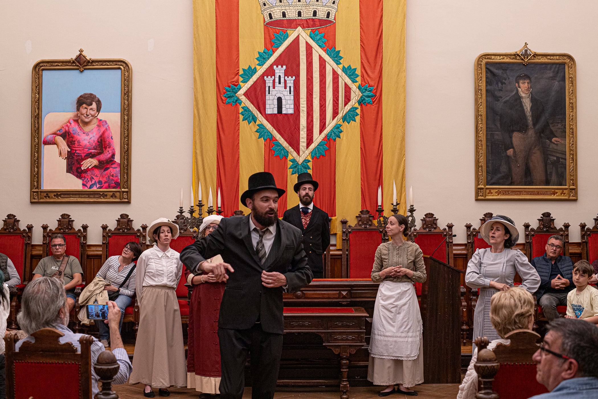 El segon i últim matí d'aquest diumenge de la XXIII Fira Modernista de Terrassa ens porta en aquest recorregut gràfic per les salves dels trabucaires entre carlins i federals, les lluites obreres de la Unió General de Treballadors per unes millors condicions a les empreses tèxtils, una visita com el 1900 al saló de plens de l'Ajuntament amb Farga'm Teatre, artistes, músics i tota mena de personatges d'època. Arrodonit, a la plaça Vella, amb una trobada entre corals, cobla i sardanistes, a càrrec de l'Agrupació Folklòrica Amunt i Crits, ballant al so, entre altres, d'Enric Morera i les lletres de Joan Maragall | Javi González