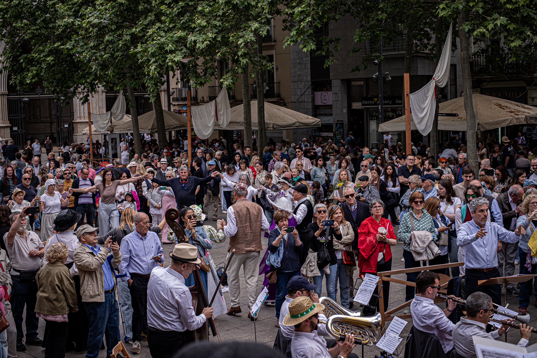 El segon i últim matí d'aquest diumenge de la XXIII Fira Modernista de Terrassa ens porta en aquest recorregut gràfic per les salves dels trabucaires entre carlins i federals, les lluites obreres de la Unió General de Treballadors per unes millors condicions a les empreses tèxtils, una visita com el 1900 al saló de plens de l'Ajuntament amb Farga'm Teatre, artistes, músics i tota mena de personatges d'època. Arrodonit, a la plaça Vella, amb una trobada entre corals, cobla i sardanistes, a càrrec de l'Agrupació Folklòrica Amunt i Crits, ballant al so, entre altres, d'Enric Morera i les lletres de Joan Maragall | Javi González