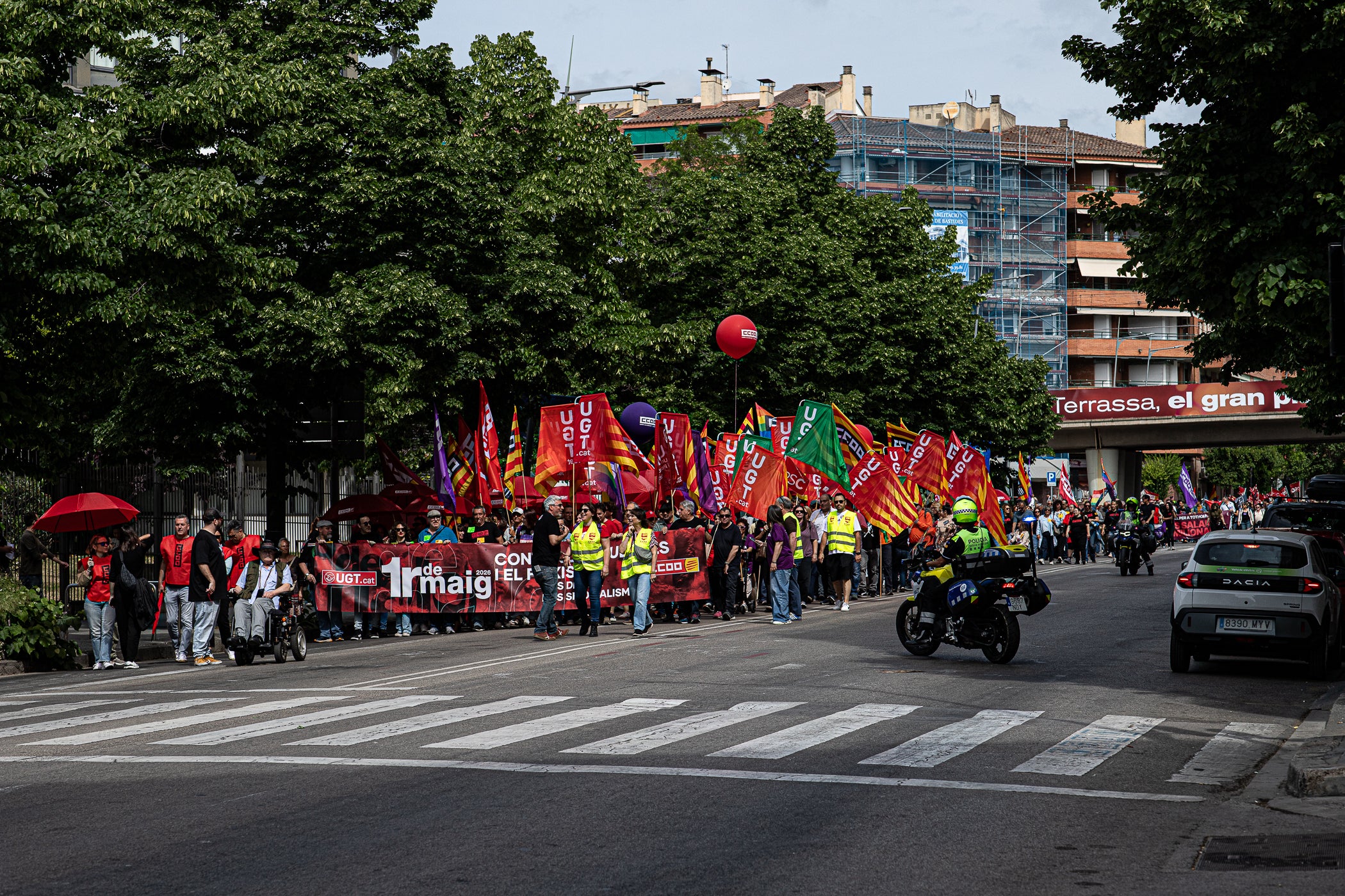 “Contra les guerres i el feixisme, més drets i més sindicalisme” ha estat el lema de la manifestació d’aquest 1r de Maig convocada pels sindicats CCOO i UGT. A Terrassa, desenes de persones han sortir des de la plaça de Lluís Companys armats amb banderes i càntics per reivindicar els drets socials i laborals dels treballadors, per denunciar l’especulació i els preus abusis en l’habitatge i per reclamar que es deixi de “criminalitzar les persones treballadores que emmalalteixen”. La convocatòria ha finalitzat a la plaça Vella on s’han fet els parlaments, posant l’èmfasi en les conseqüències negatives en la qualitat de vida de la ciutadania que estan tenint els “conflictes bèl·lics il·legals de Netanyahu, Trump i Putin”.