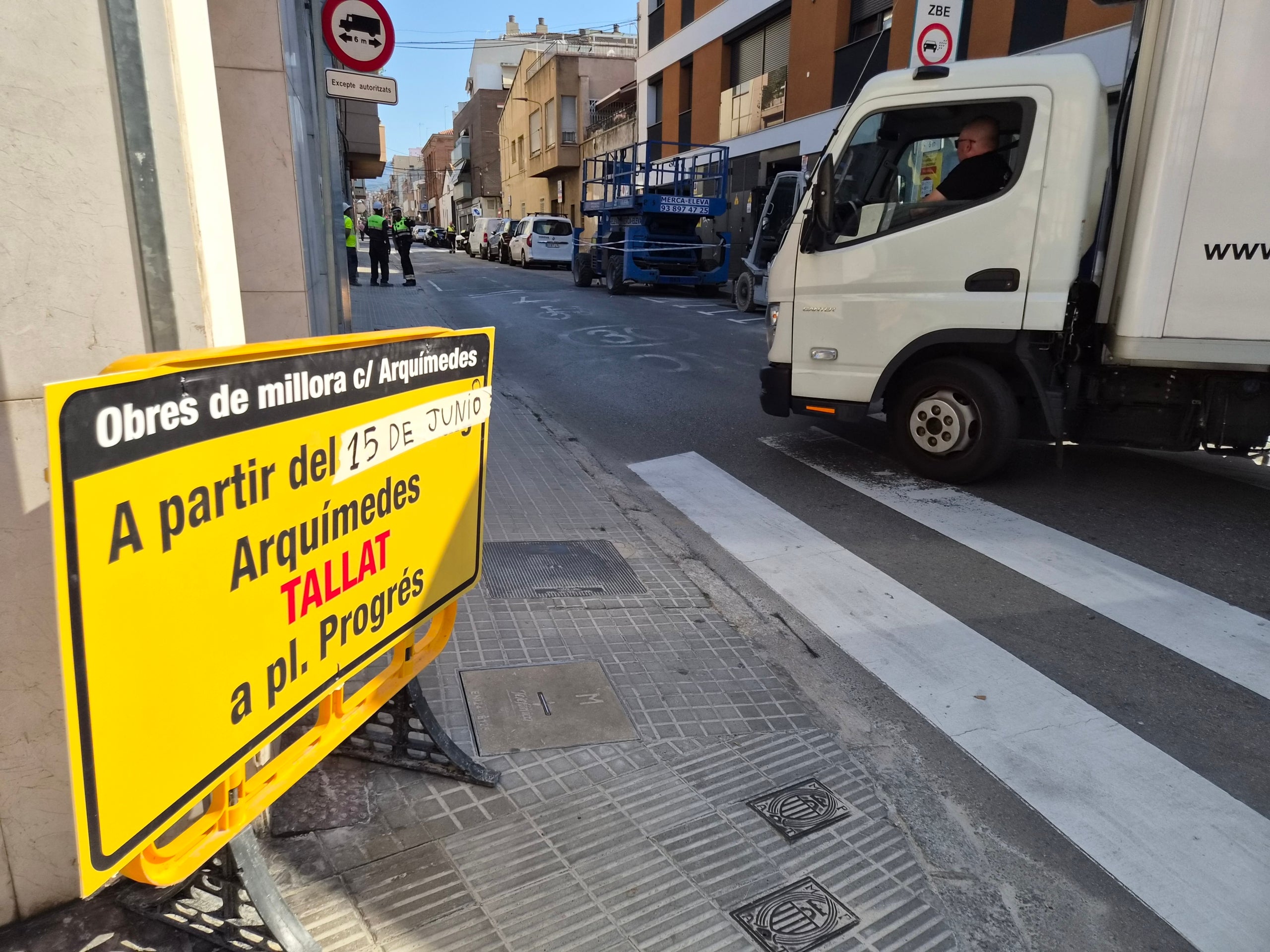 Aquest dilluns dia 15 de juny han començat les obres de pacificació del carrer d’Arquimedes de Terrassa. Des de bon matí, operaris han estat col·locant les tanques i cartells amb les afectacions de trànsit advertint els conductors des de la carretera de Martorell. I és que ha quedat totalment tallada la circulació entre plaça del Progrés i Grànius. D’aquesta manera, malgrat que la voluntat de l’Ajuntament és que els vehicles ja no entrin per Arquimedes per creuar la ciutat cap al nord, han estat molts que s’han esperat fins a trobar la reixa metàl·lica que impedia el pas per buscar una alternativa. Cal dir que no ha estat fins passades les dotze del migdia quan no s’ha tancat definitivament. Fins aleshores, els vehicles podien passar, tot i que diversos agents de la Policia Municipal de Terrassa, repartits al llarg d’Arquimedes, informaven els conductors de l’actuació. Recordem que la previsió és finalitzar les obres el febrer de 2027, i la voluntat del Consistori és aconseguir en aquest temps un canvi real d’hàbits i donar impuls a l’ús de les rondes de la ciutat.