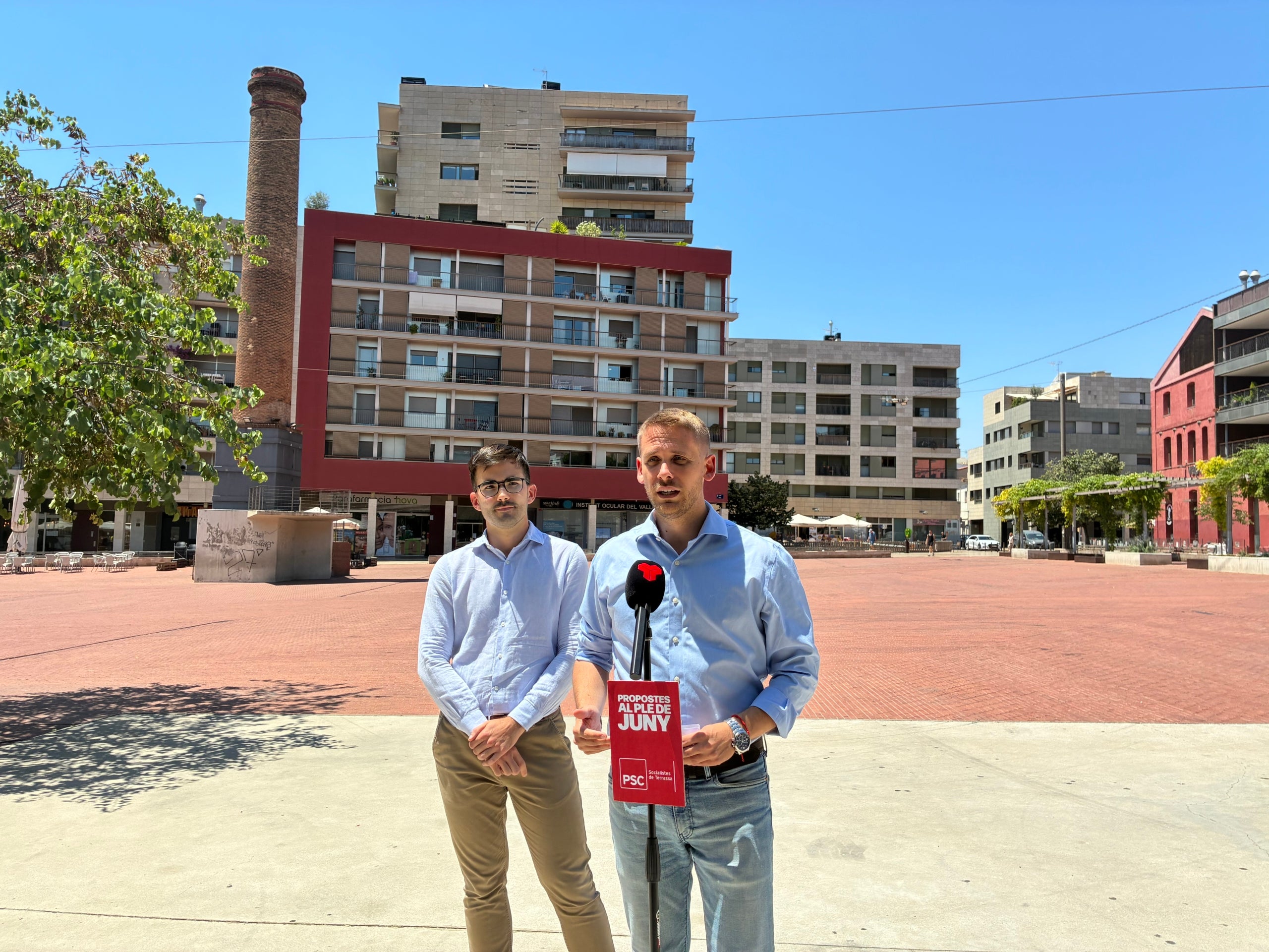 Els regidors socialistes Adrián Sánchez i l'alcaldable Javi García, en la roda de premsa enmig d'un sol de justícia a la plaça Nova de Terrassa aquest divendres al migdia | Vicenç Batalla