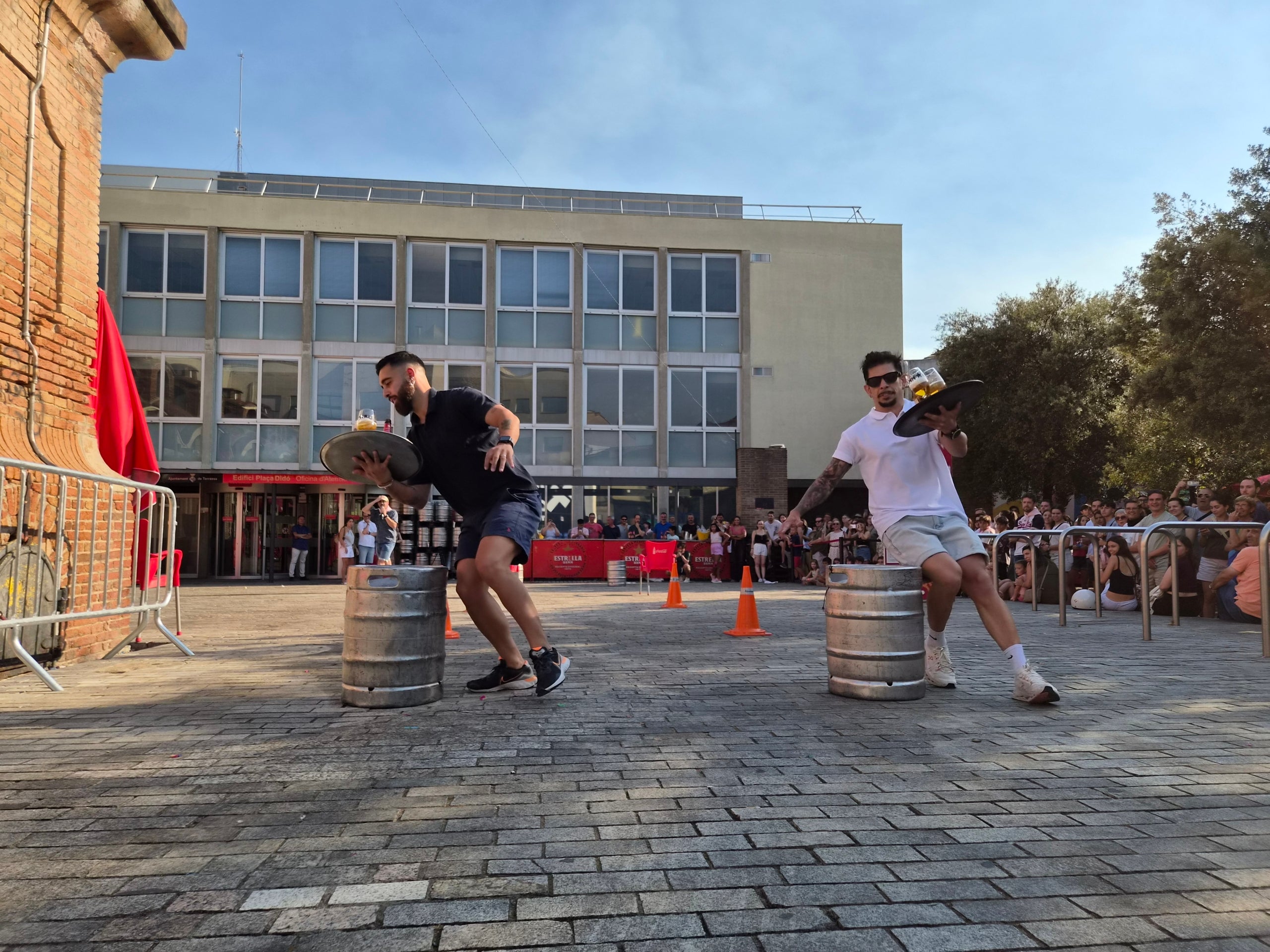 La plaça Didó va acollir aquest dilluns a la tarda dos dels grans clàssics de la Festa Major de Terrassa: la cursa de cambrers i el concurs d’apilar caixes. Ambdues activitats són organitzades pel Gremi Empresarial d’Hostaleria de Terrassa i Comarca i requereixen inscripció prèvia. Gran expectació per veure qui és el cambrer més ràpid i àgil de la ciutat en una competició que semblava en algun moment de trencament d’ampolles i copes. Una estona després, a la mateixa plaça, el concurs d’apilar caixes no va decebre -i va batre rècord de participanrs- i els més valents van posar a prova les seves habilitats i força per pujar com més amunt millor.