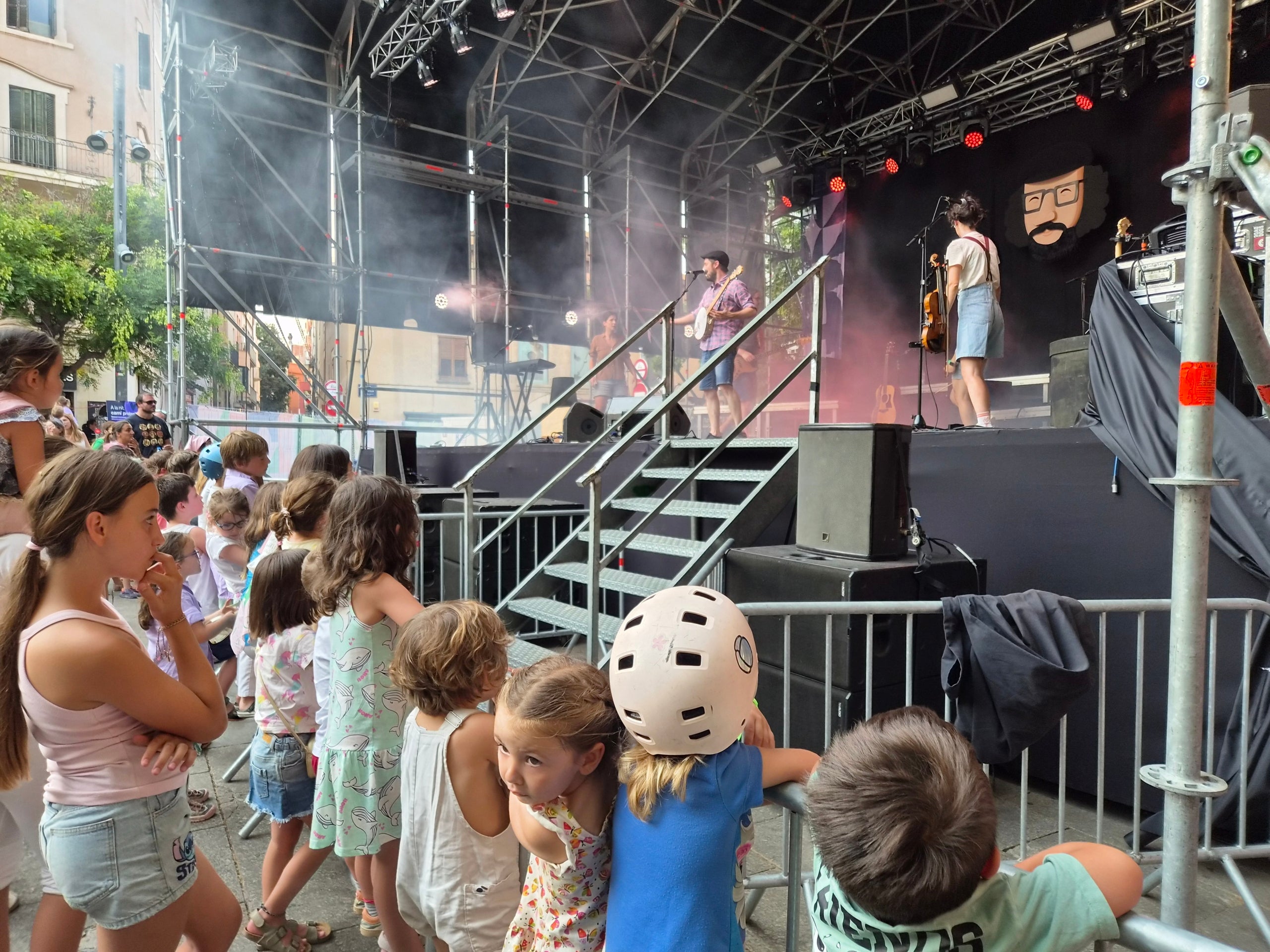La plaça Vella s’ha omplert aquest dilluns de famílies i canalla pel concert d’Ebri Knight. L’Albert, l'Alba, la Laia, en Toni i l’Arnau han fet ballar i cantar des de dalt de l’escenari al públic assistent que no ha perdut en cap moment el ritme. La banda ha presentat el seu projecte de música familiar “Bon vent!”, en el qual volen transmetre a les generacions del segle XXI l’esperit d'en Xesco Boix. La gira va començar el 2025, i ja porten centenars de concerts a les espatlles en què reivindiquen allò bàsic que no cal perdre: una infància feliç, connectada a la música i la cultura, a la comunitat i a la germanor.