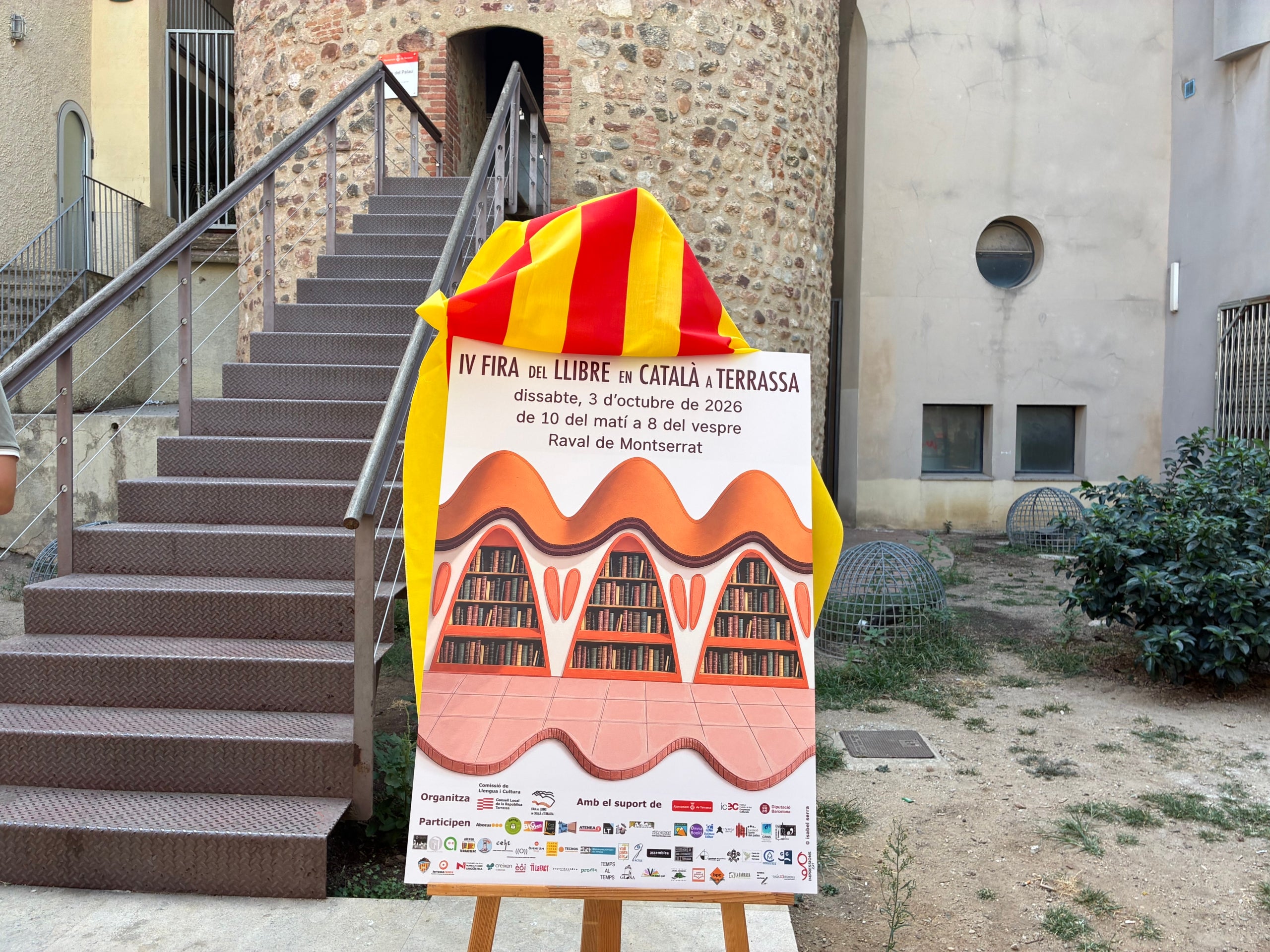 El cartell de la IV Fira del Llibre en Català a Terrassa, obra d'Isabel Serra, en la presentació a la plaça de la Torre del Palau | Vicenç Batalla