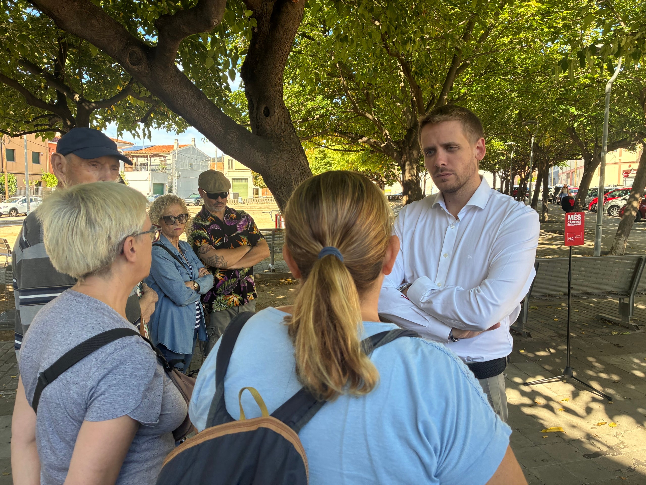 El regidor socialista i candidat a les municipals Javi García parlant amb veïns a la plaça Jaume Vicens Vives del barri d'Ègara de Terrassa sobre temes de seguretat | Vicenç Batalla