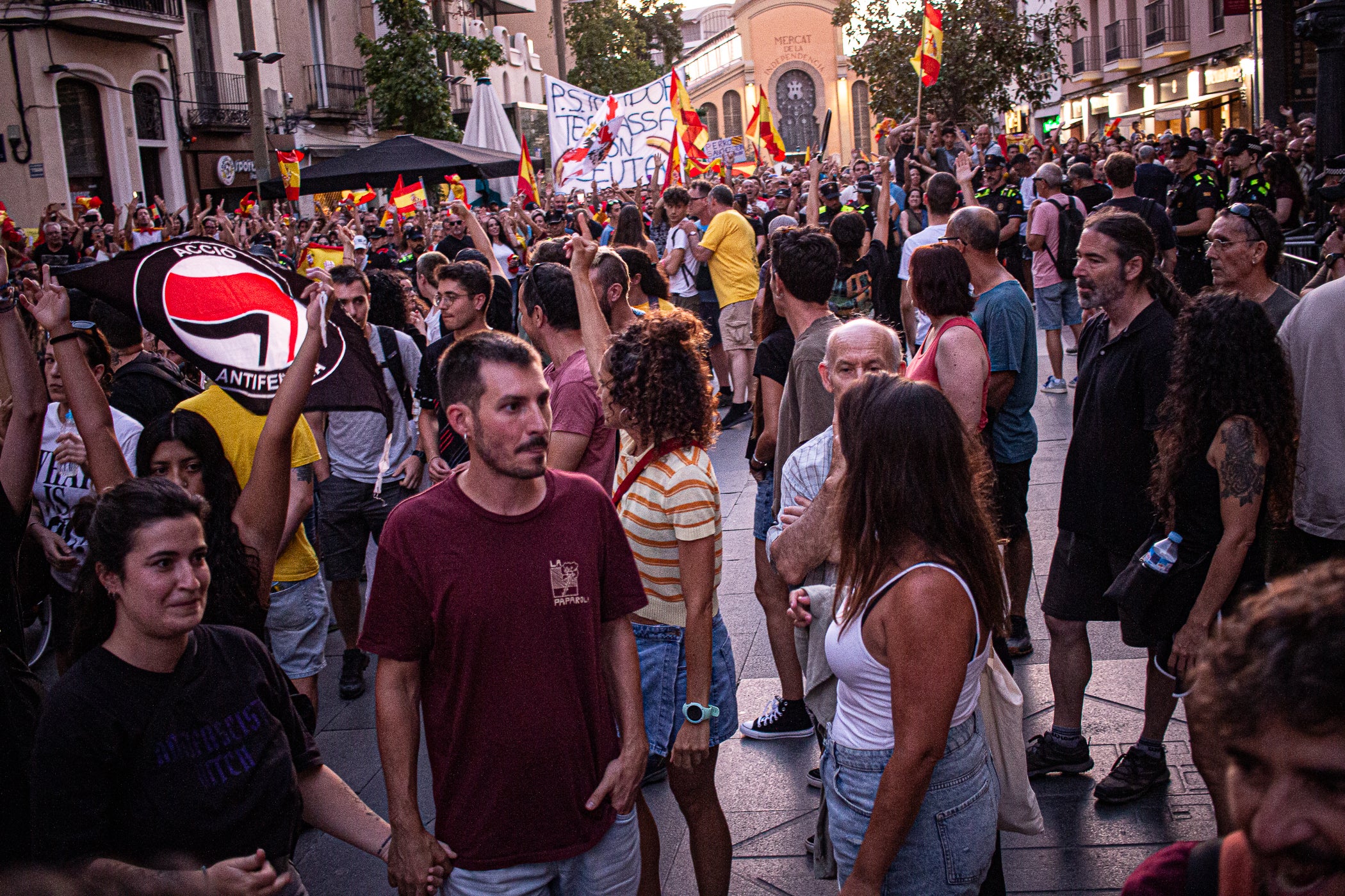 El Raval de Montserrat ha acollit aquest dimecres, dia 2 de setembre, una doble concentració amb Ceuta com a protagonista. Per una banda, hi havia “Por Ceuta, Unidos por España”, una iniciativa sorgida des de les xarxes socials i secundada per partits com PP i VOX, que vol donar suport al municipi en aquests moments de crisi migratòria. Mentre que com a rèplica, des de la Unitat Contra el Feixisme i el Racisme havien demanat a la ciutadania omplir l'espai amb una Jam musical contra la intolerància. Com era inevitable, les dues s'han acabat trobant, i això ha provocat alguns moments de tensió, però la forta presència policial ha impedit que la cosa anés a més, tot i que els crits a banda i banda s'han fet sentir. Des dels antifeixistes s’ha denunciat públicament la presència de banderes i simbologia racista i la seva impunitat per exhibir-la.