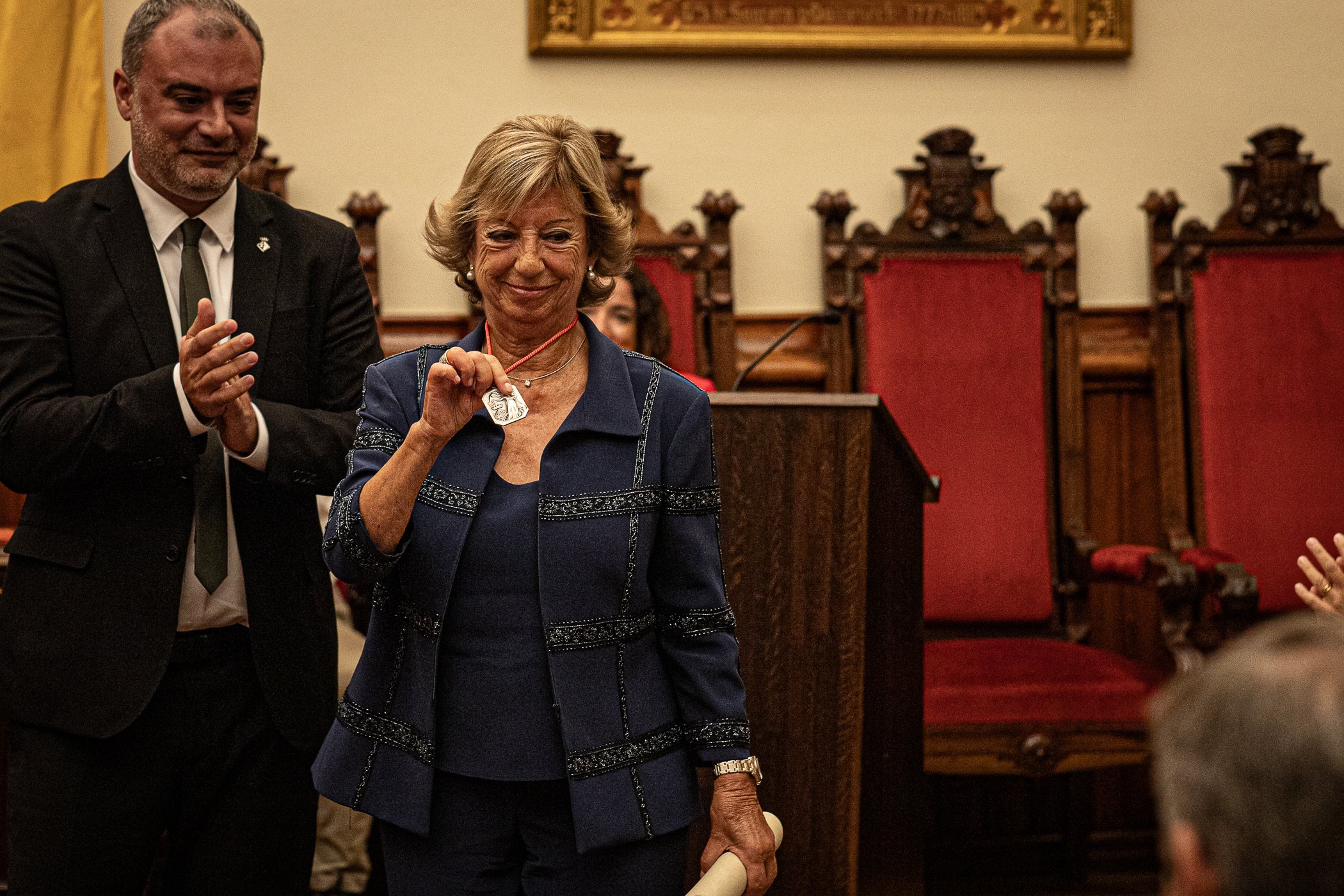 La jurista Maria Vidal Sanahuja va rebre aquest dimarts la Medalla d'Honor de la Ciutat de Terrassa, en un acte institucional al saló de plens de l'Ajuntament, en què se li va reconèixer la seva tasca com a pionera de l'advocacia a Catalunya i l'Estat espanyol. Primera degana dona del Col·legi d'Advocats de Terrassa, entre 1999 i 2006, i presidenta del Consell de l'Advocacia Catalana, entre 2003 i 2004, actualment és consellera del Consell General de l'Advocacia Espanyola, a més de vicepresidenta del Patronat de LaFACT. El degà emèrit de Col·legi d’Advocats terrassenc, Ignasi Puig i Ventalló, en fa fer una glossa abans que l'alcalde, Jordi Ballart, li posés la medalla i Vidal pronunciés un discurs, rodejada d'amics i familiars | Javi González