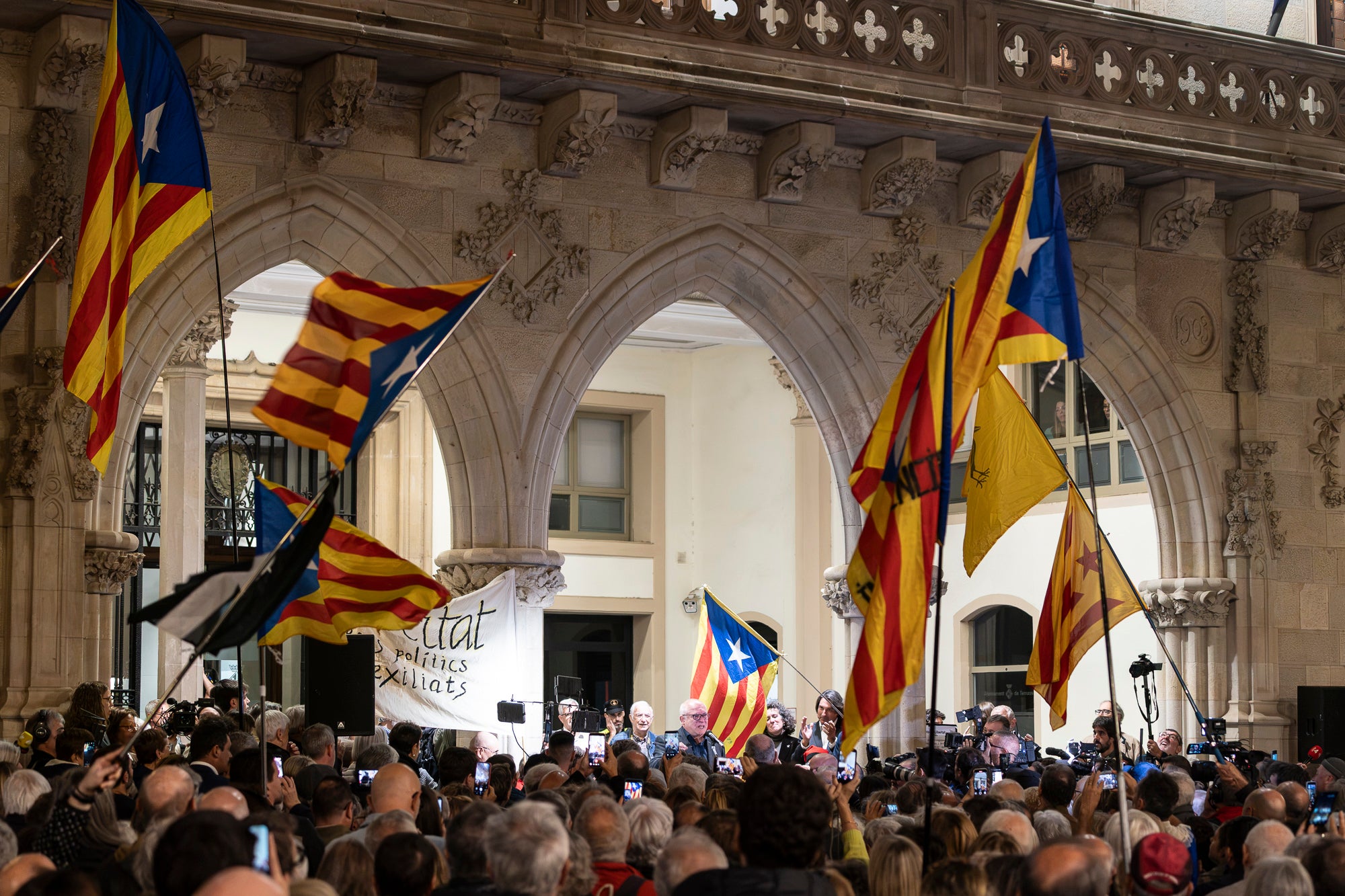 El raval de Montserrat de Terrassa es va omplir de gom a gom aquest dimecres al vespre, amb una jornada dels Cants de Llibertat especial i esperada, per la rebuda de l'exconseller Lluís Puig gairebé nou anys després del seu exili pel referèndum de l'1 d'Octubre. Sense ordre de detenció i a punt de ser amnistiat, un Puig emocionat estava acompanyat per la plana major de Junts per Catalunya, el dia abans d'ocupar per primer cop físicament el seu escó al Parlament. I també per tots aquells terrassencs i terrassenques que esperaven que tornés a casa, inclòs l'alcalde, Jordi Ballart. Fins i tot, el va sortir a saludar simbòlicament el seu capgròs de Festa Major | Mireia Comas
