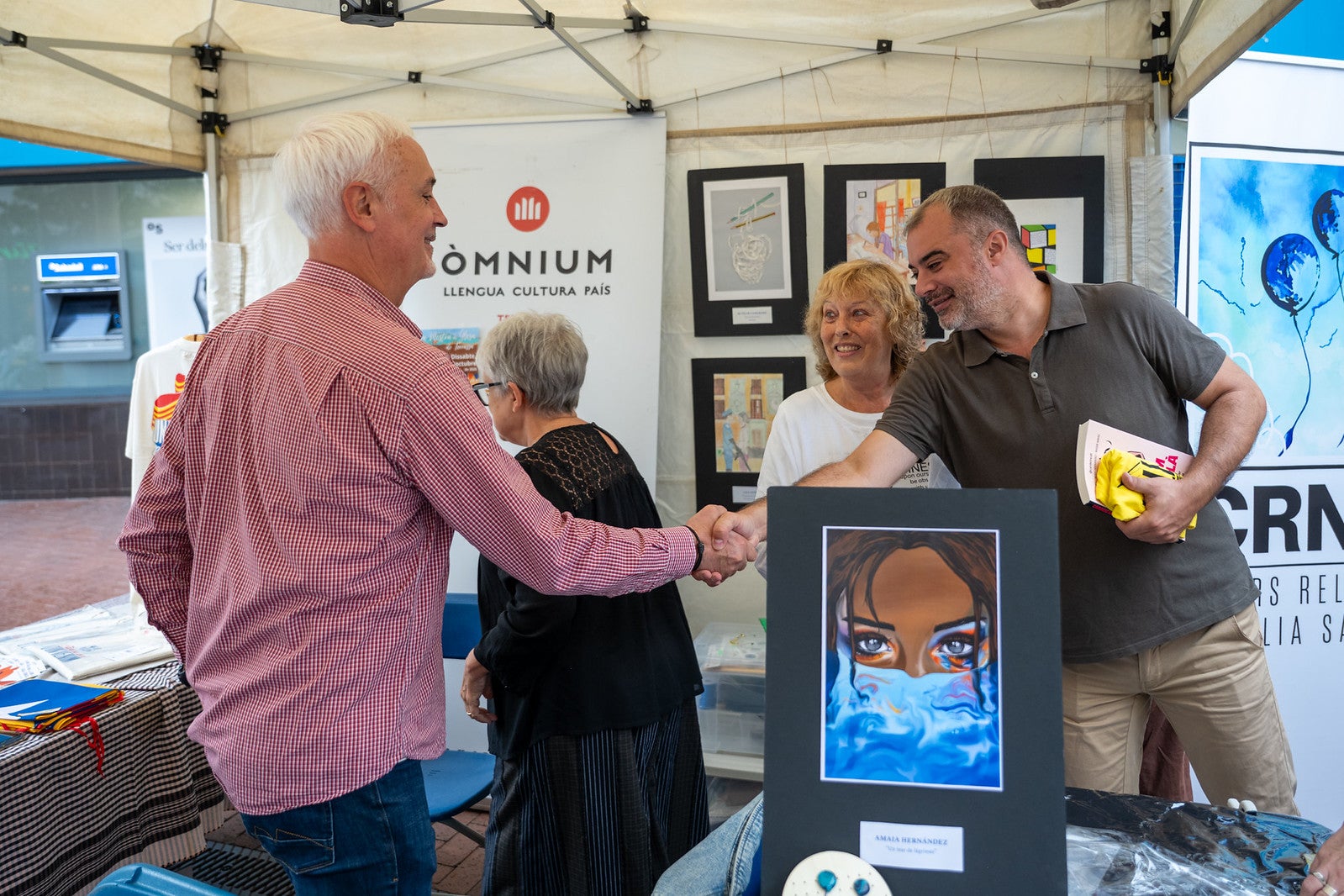 La Fira del Llibre en Català a Terrassa aquest dissabte al raval de Montserrat, organitzada per Consell Local de la República, va tenir dues parts de la jornada completament diferents. Una primera al matí, amb sol, en la qual la trentena de paradistes, amb dues llibreries de la Franja d’Aragó, van comptar amb una animada presència de visitants. I, una segona, a la tarda, en què van haver de plegar a causa de la forta pluja. Malgrat tot, es va poder celebrar a l'atri de l'Ajuntament un dels debats previstos, amb el periodista Xavi Coral fent de moderador i parlant amb els llibreters Àlvar Masllorens i Olga Federico de Professionalitat versus algoritme i les seves particulars comunitats lectores | Gemma Miralda