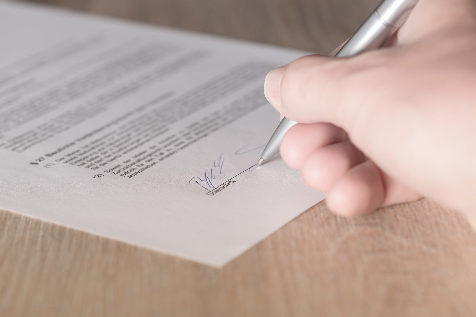 Persona signant un contracte / Pixabay